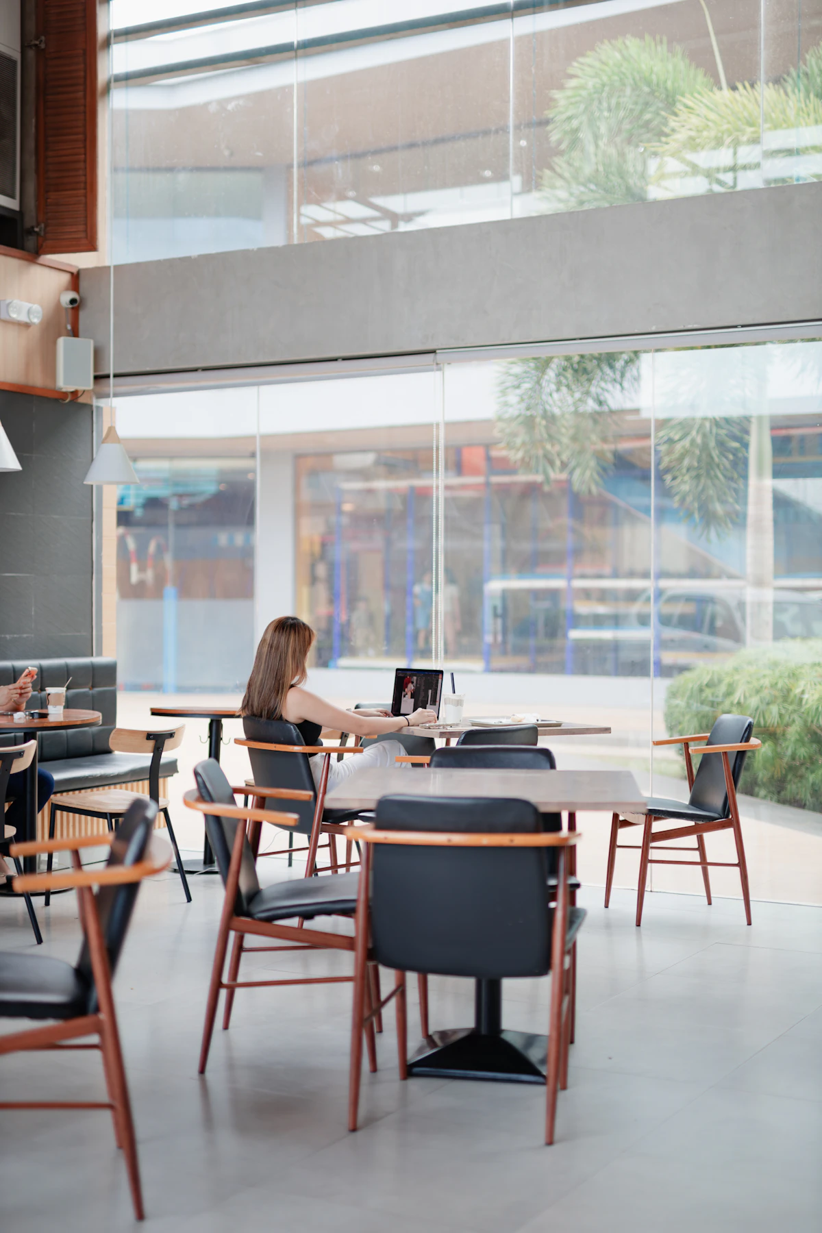 Perempuan bekerja dengan laptop di kafe modern.