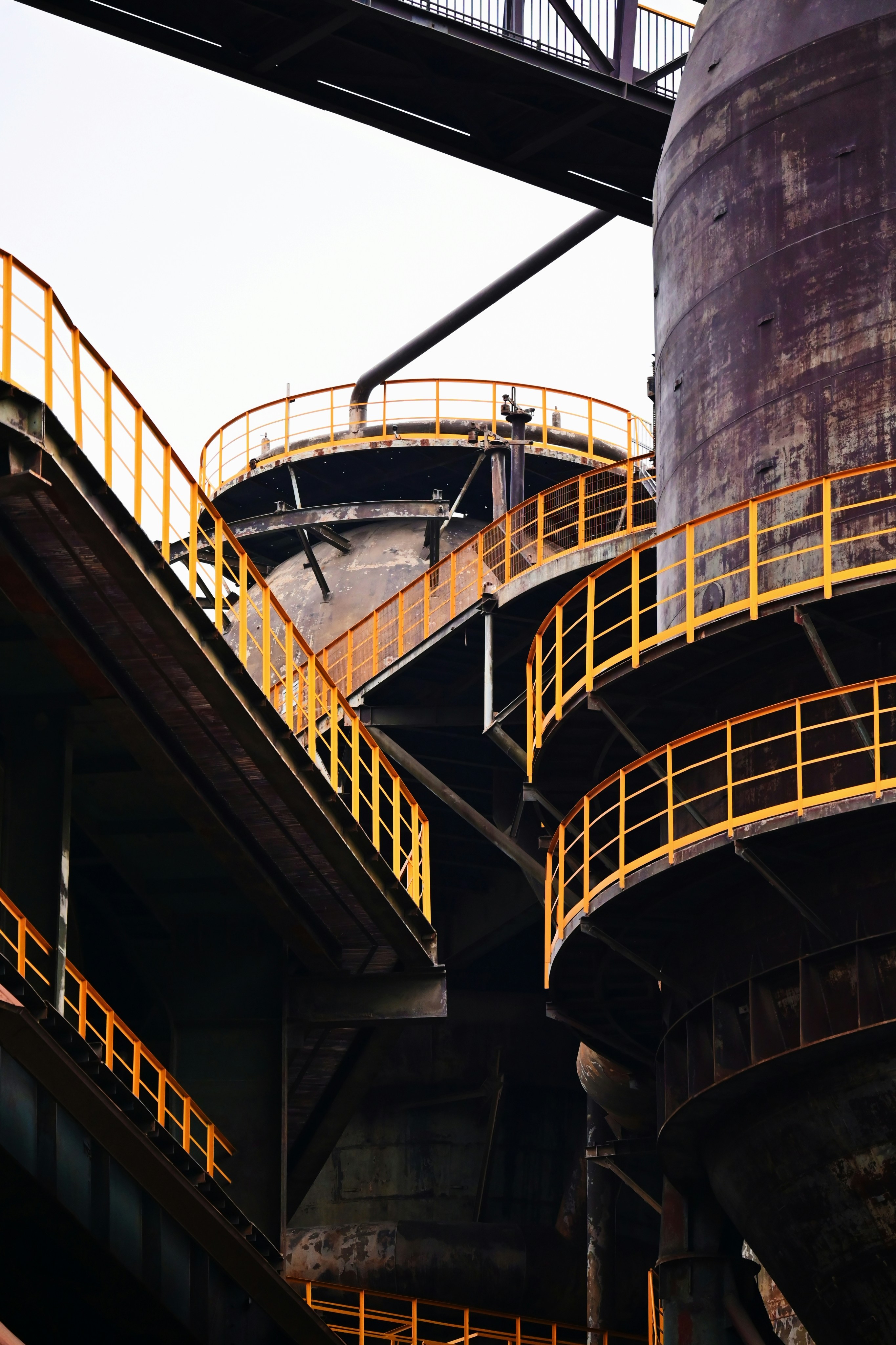 Industrial complex with rusty metal structures and yellow railings ...
