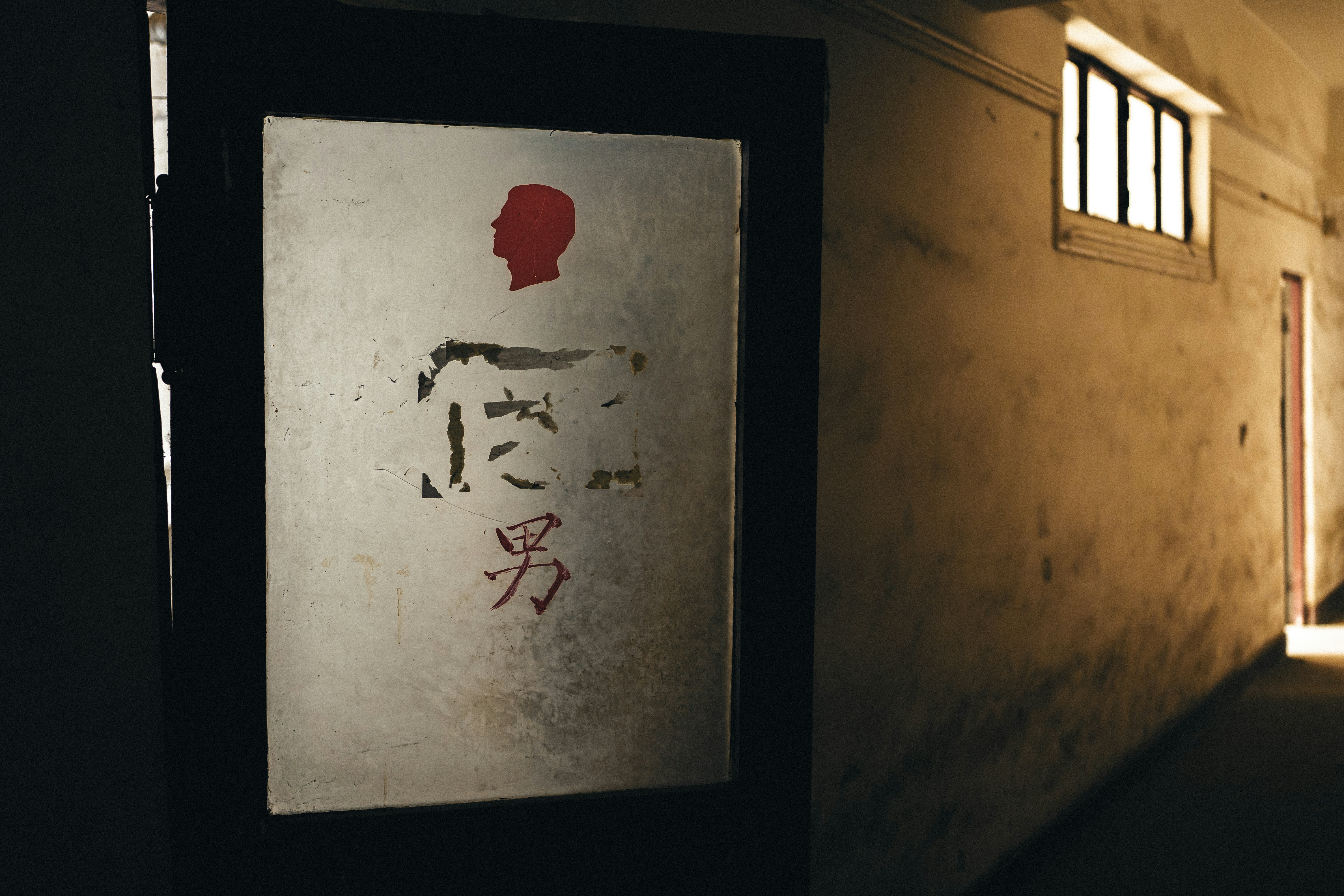 Sign with male symbol and japanese text in dark hallway