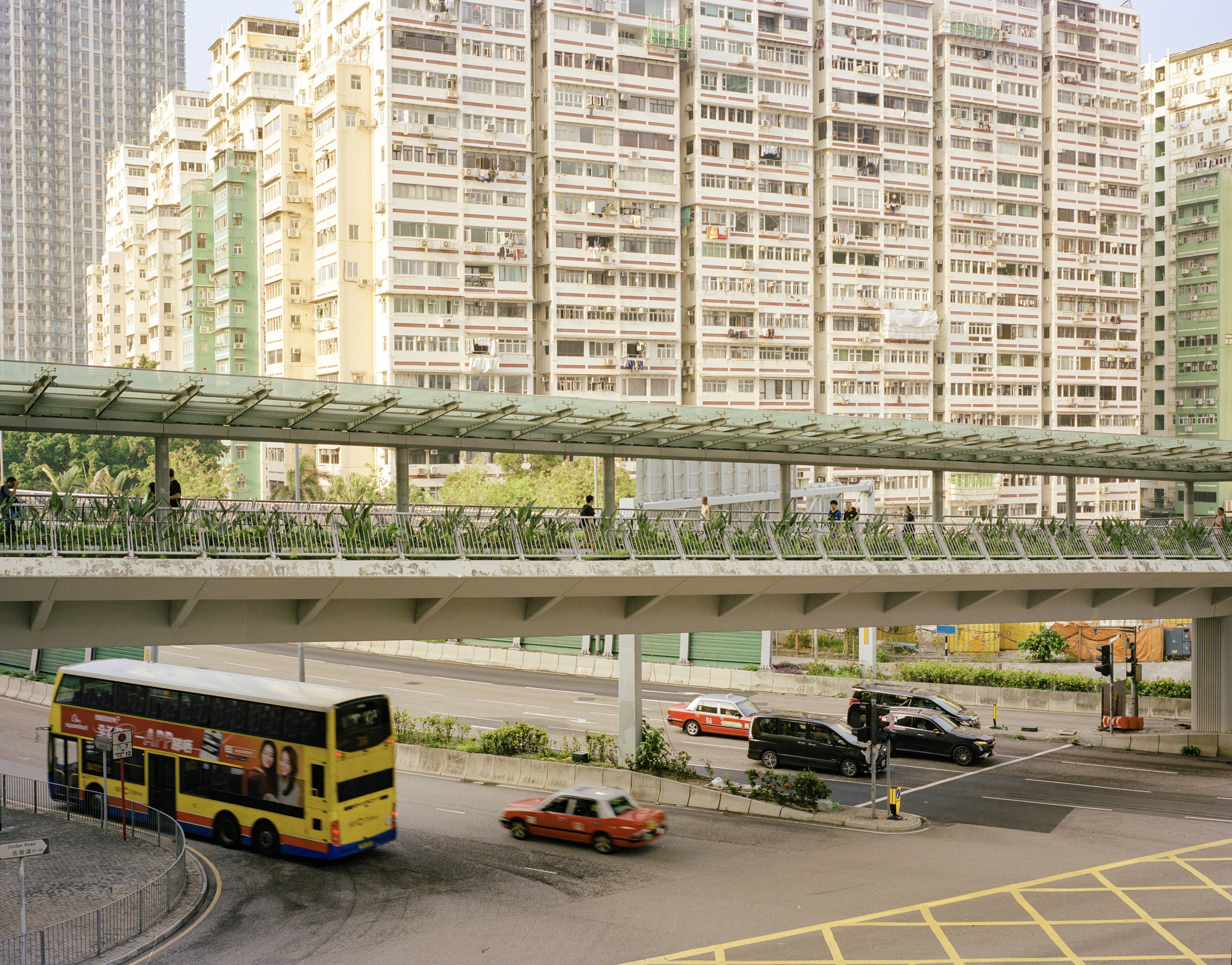 Urban scene with a double-decker bus, cars, and tall buildings.