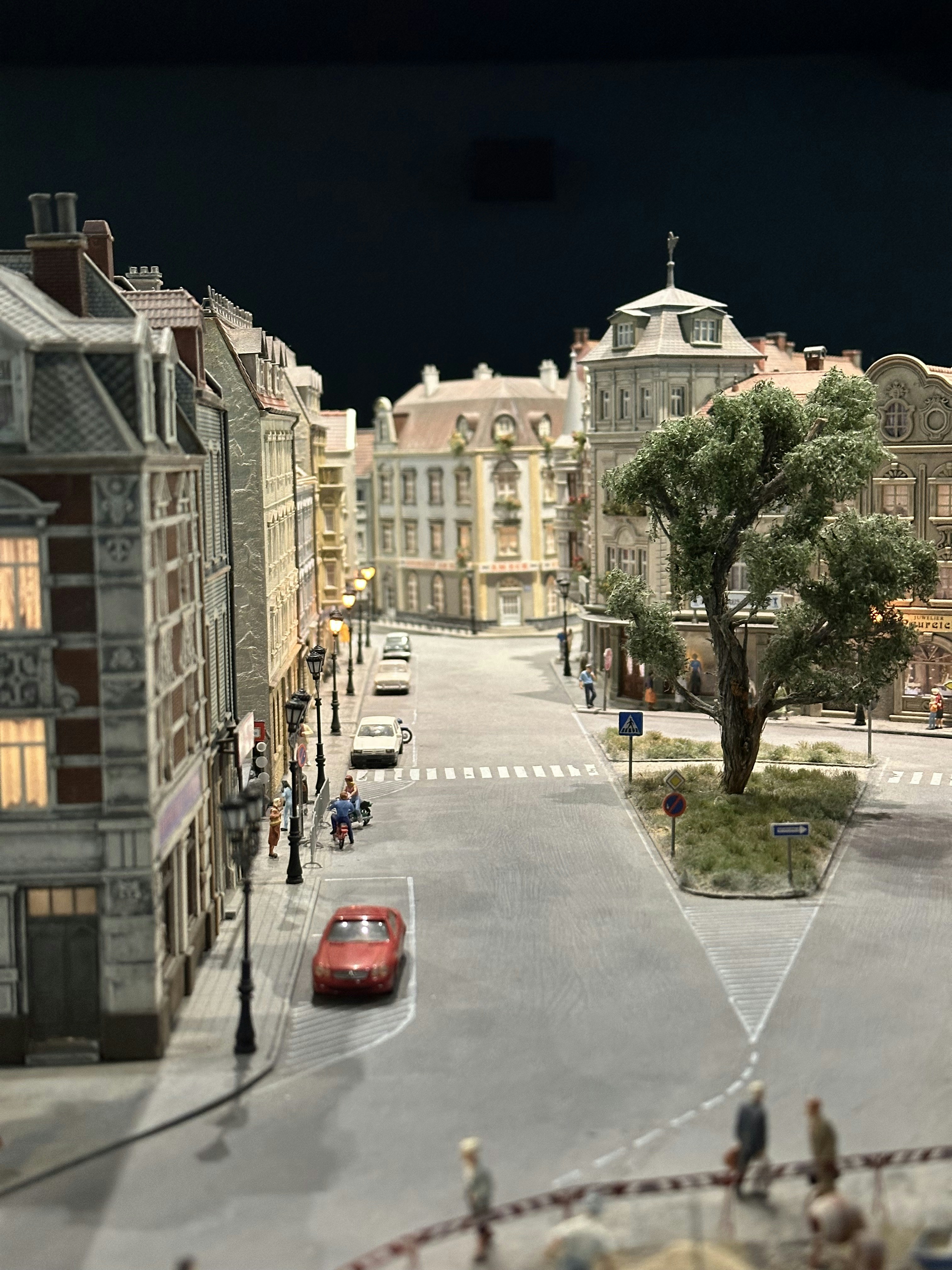 Detailed miniature town street scene with buildings, cars, and people