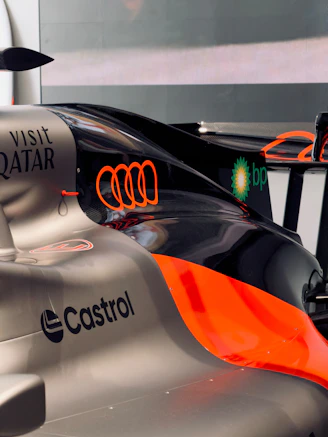 Race cars displaying audi, castrol, bp, and qatar branding