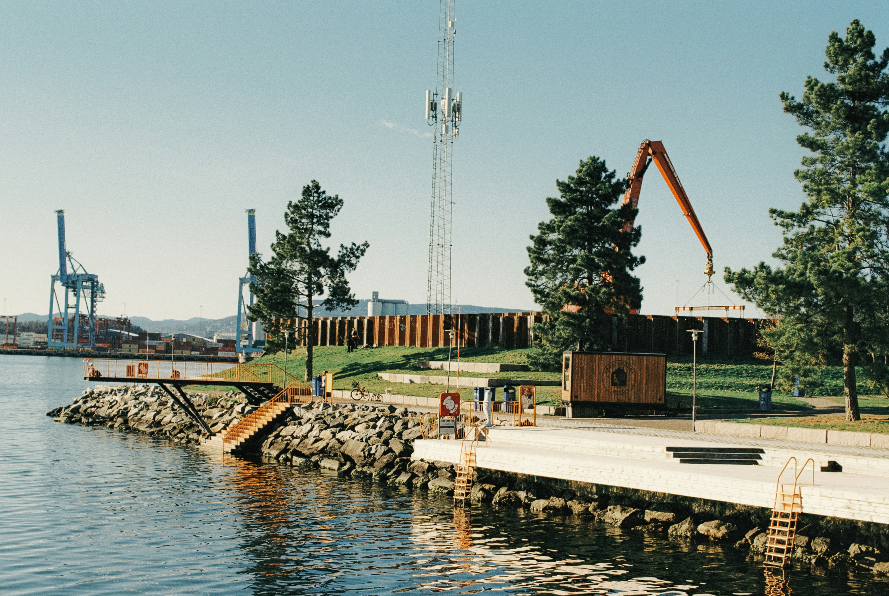 Construction site showing heavy machinery on a coastal area, contrasting with natural surroundings