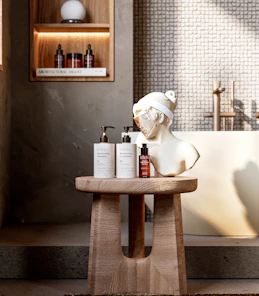 Skincare products and bust displayed on a wooden stool.