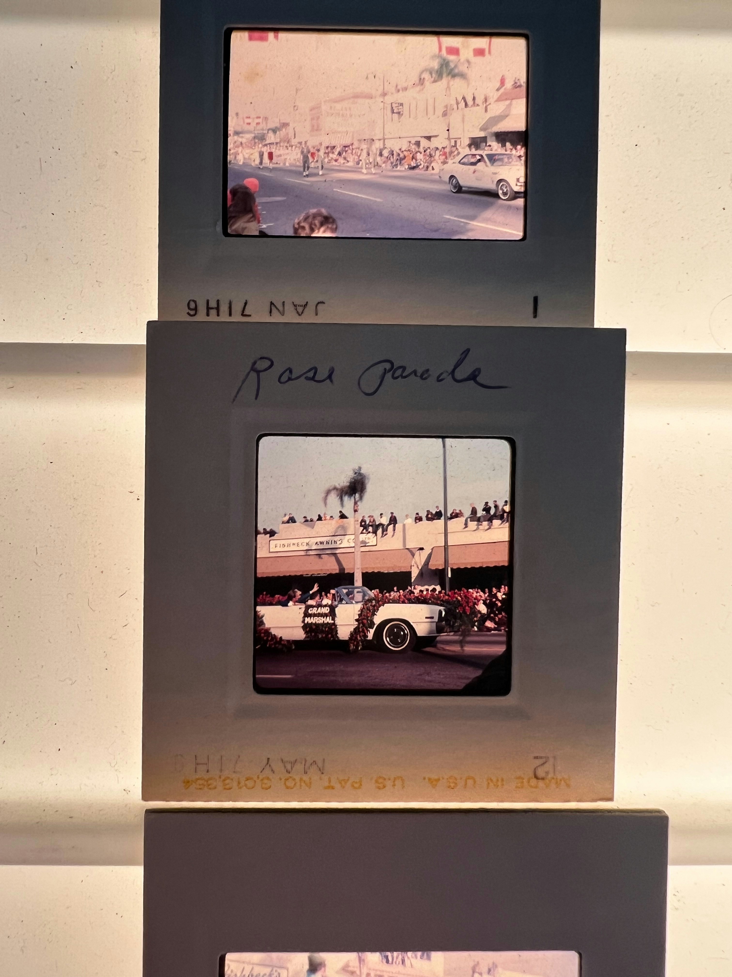 Vintage film slides displaying a parade with classic cars.