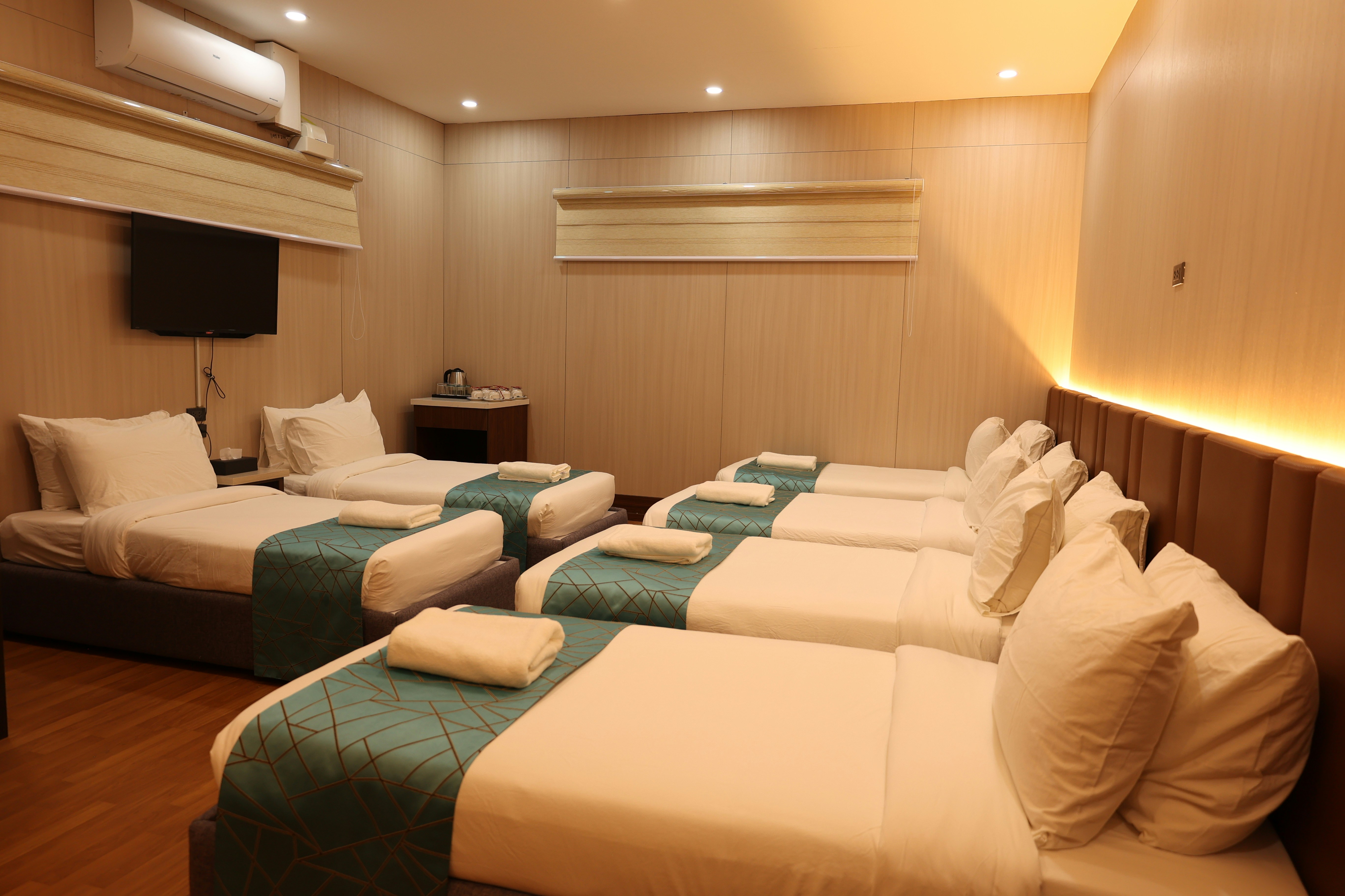 Clean, well-lit room with several neatly made beds.