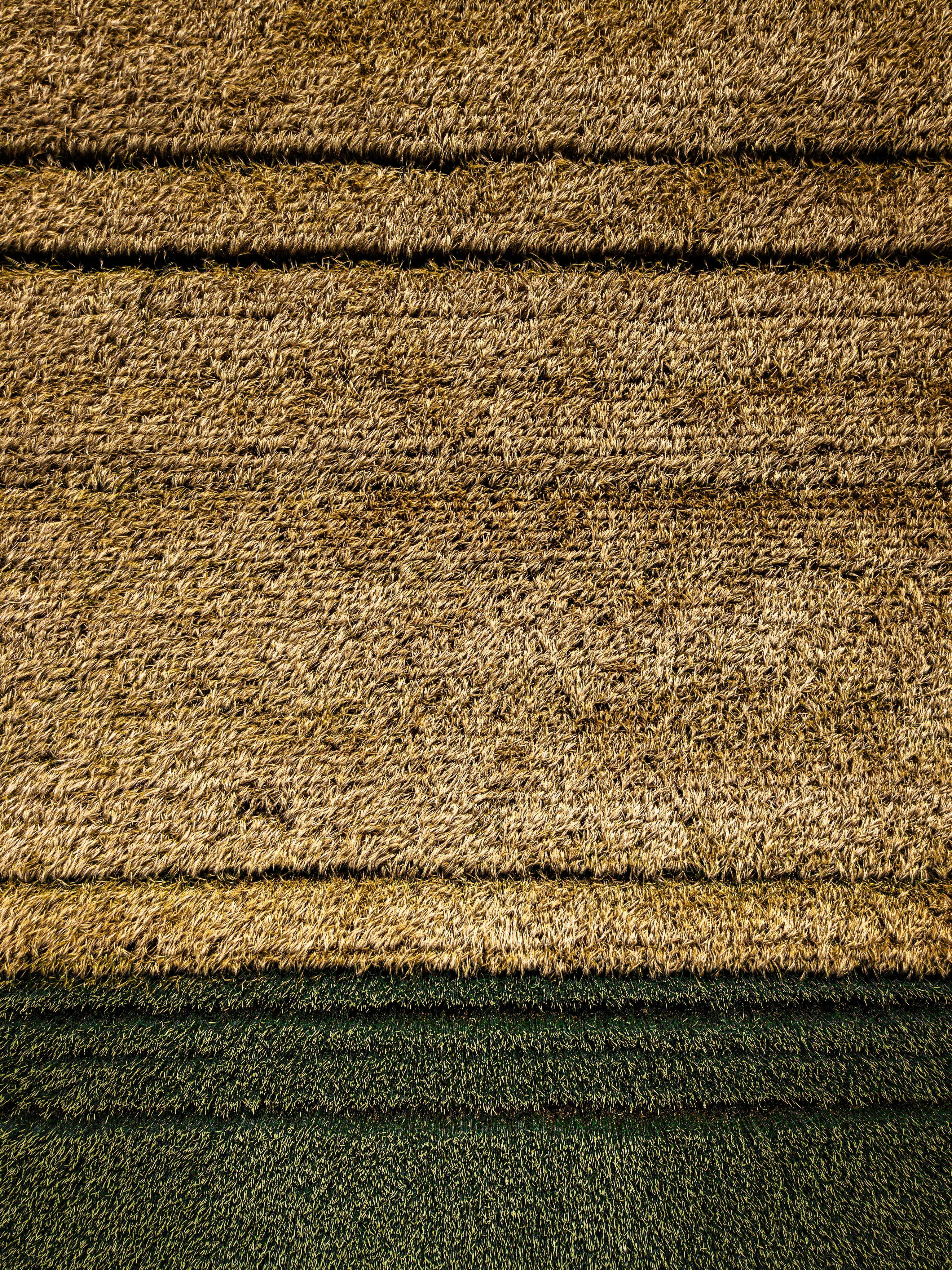 A textured rug with horizontal brown and green stripes.