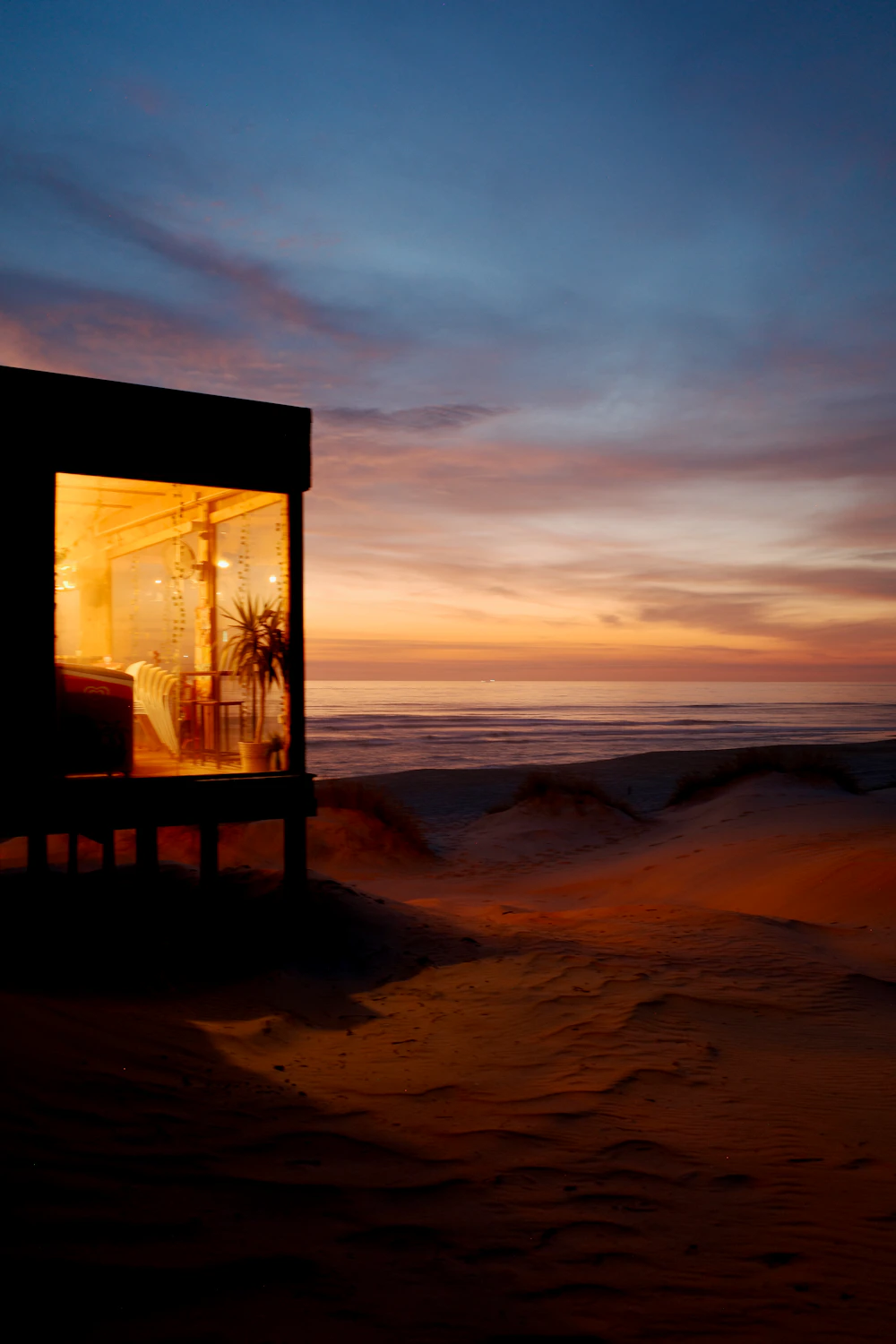 A beach house at sunset overlooking the ocean