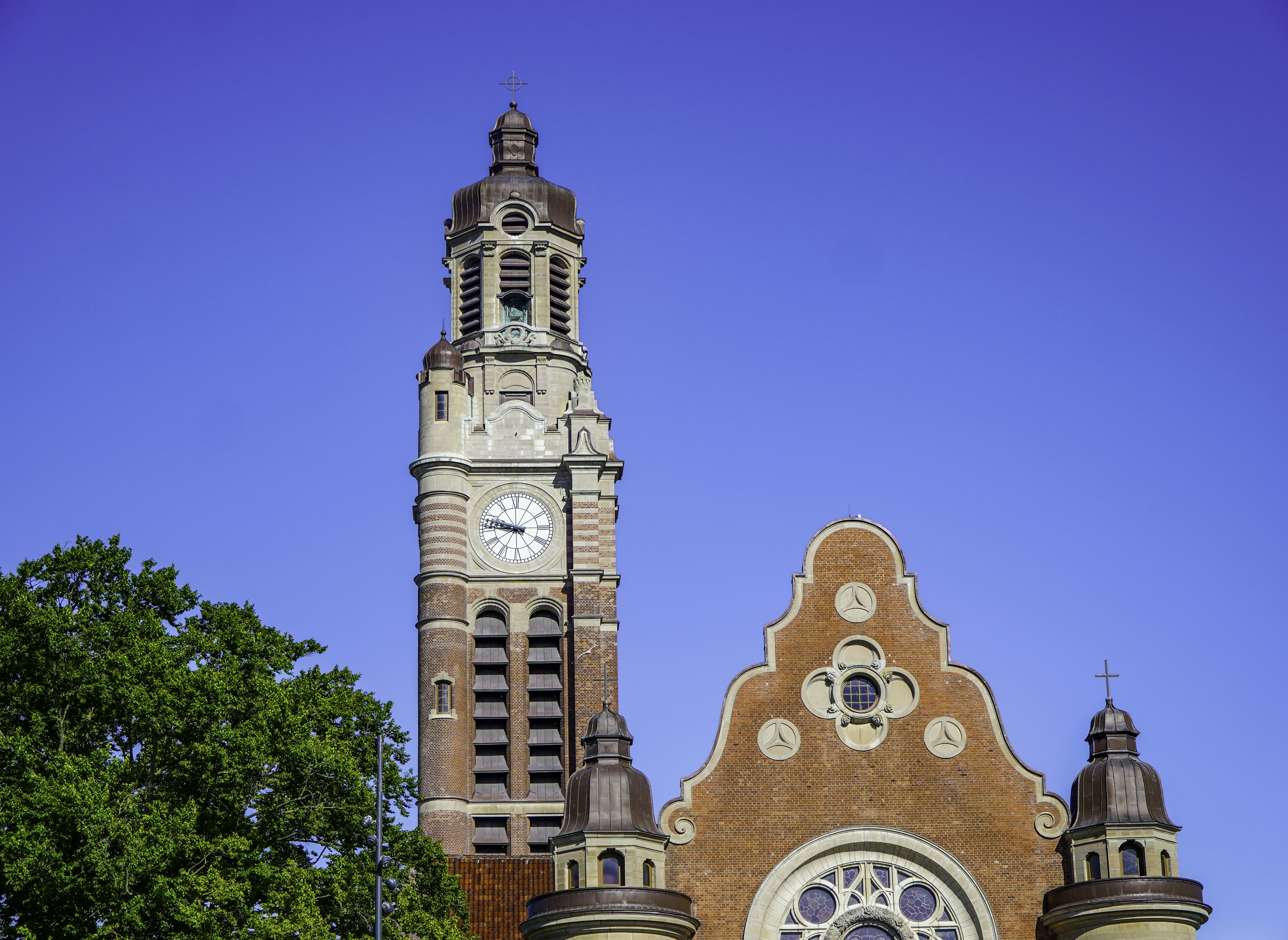 Tall brick clock tower against a clear blue sky.