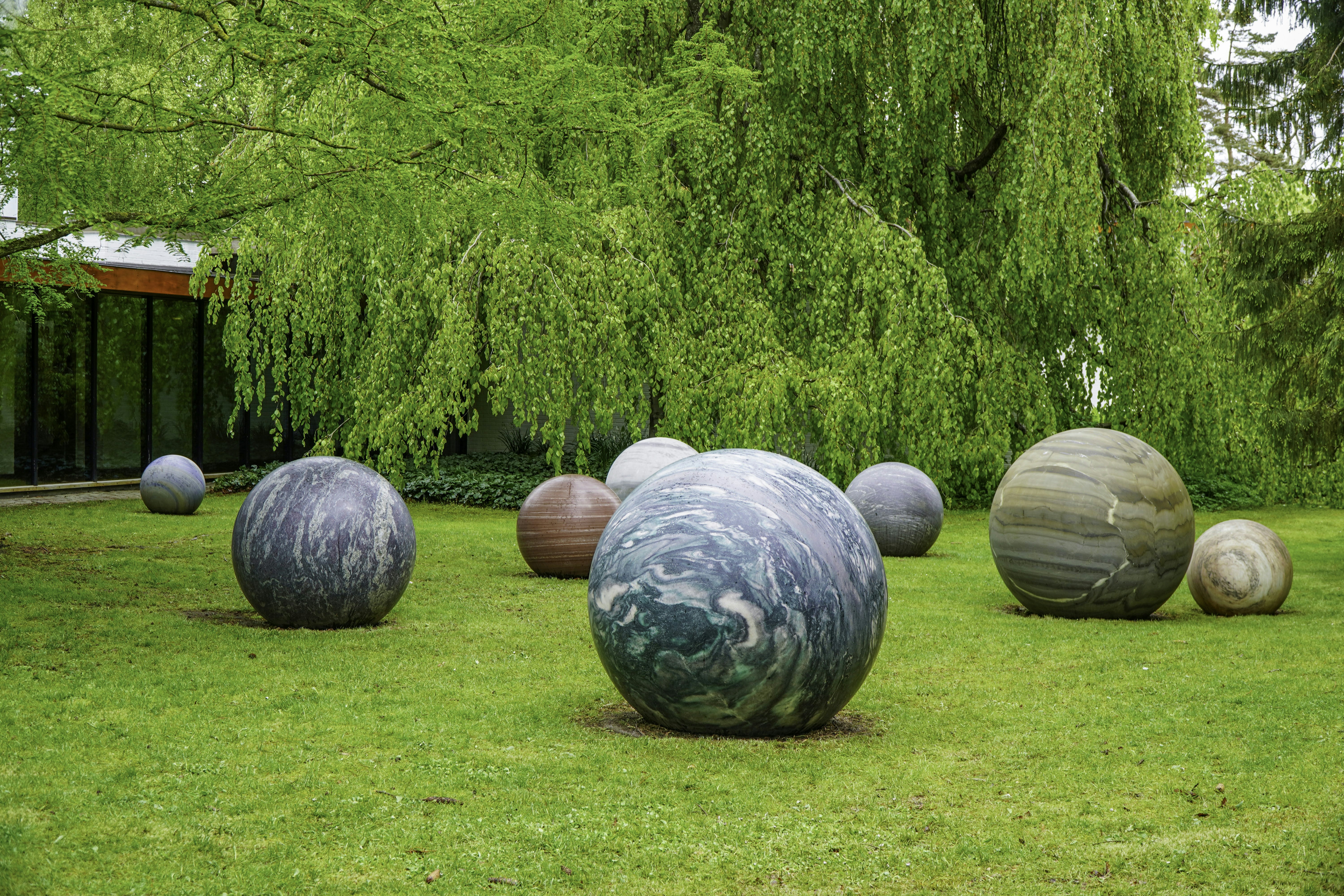 Various large, spherical patterned stones scattered on a green lawn.