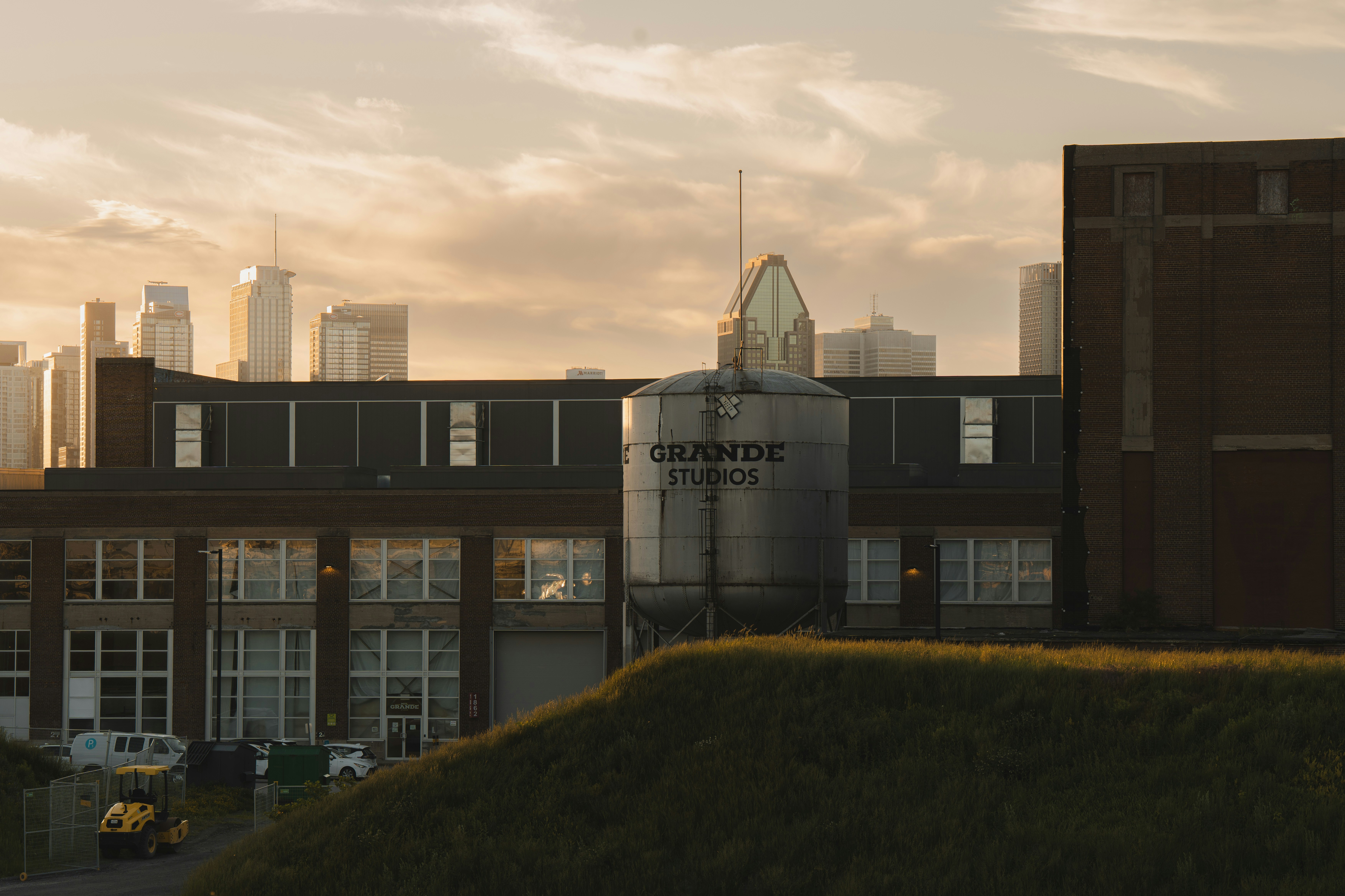 Industriegebäude mit Rochester-Tank und Stadtbild bei Sonnenuntergang.