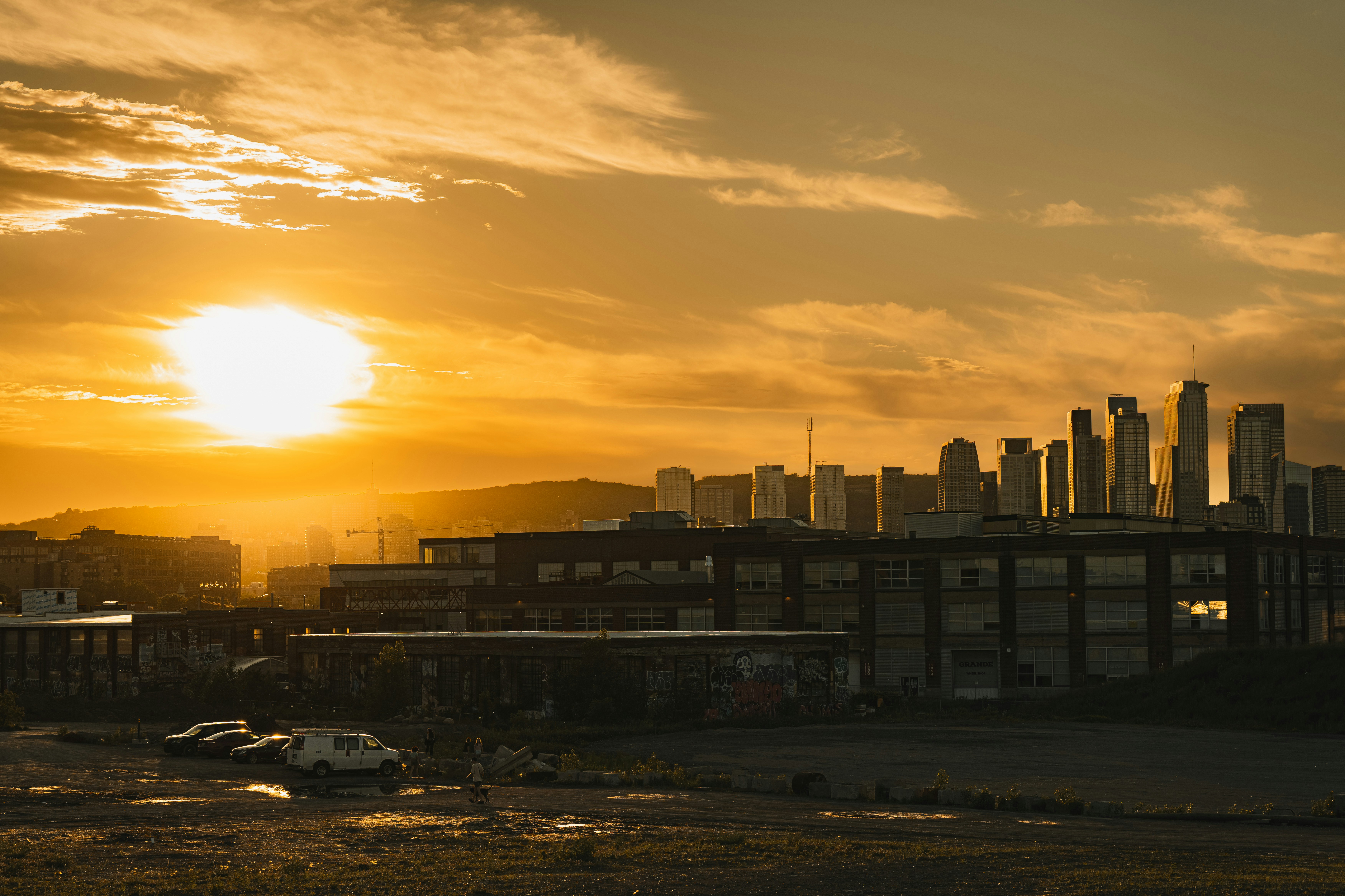 Stadtskyline bei Sonnenuntergang mit einem leuchtend orangefarbenen Himmel.