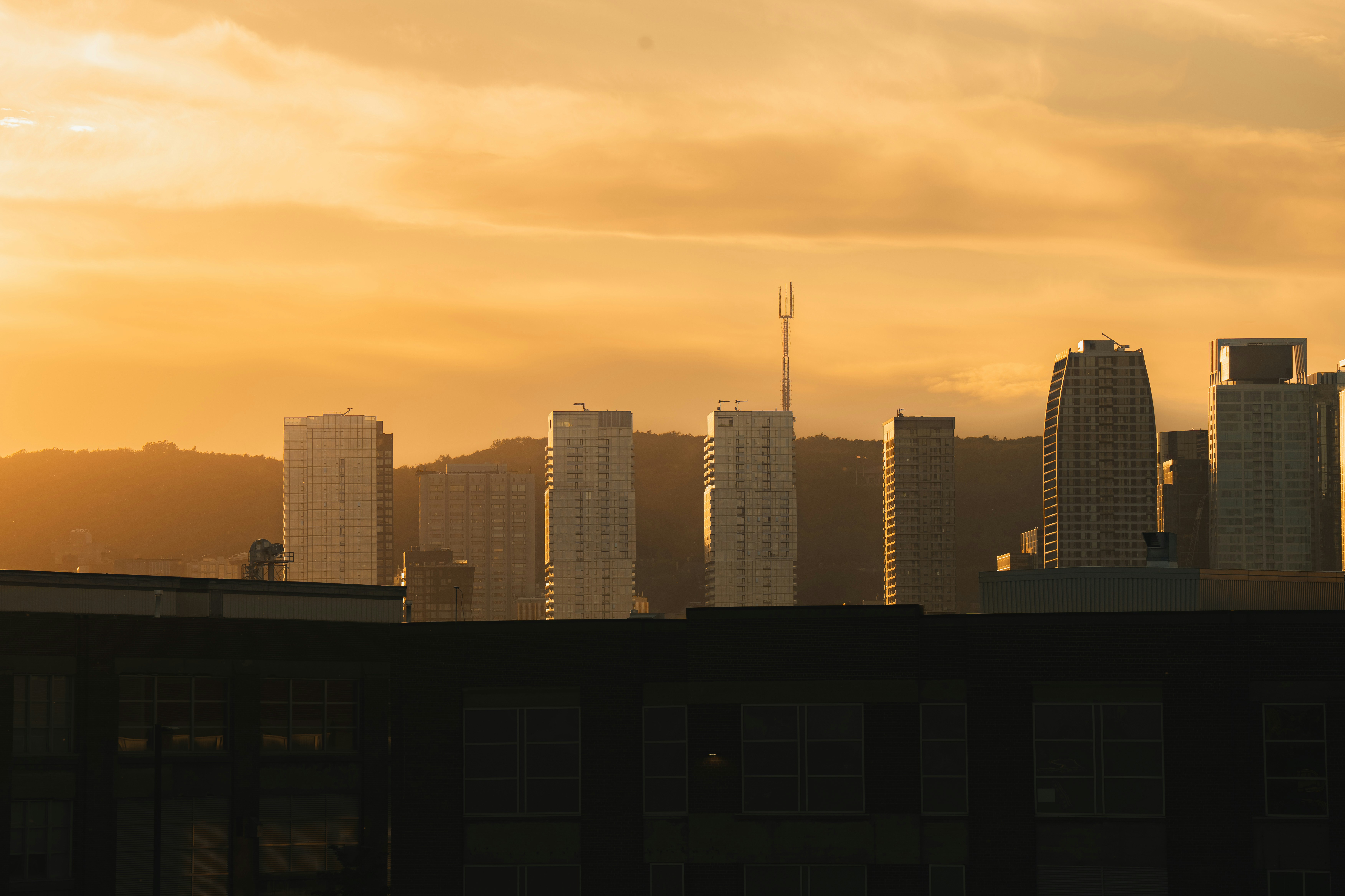 Silhouette der Stadtsilhouette vor einem lebendigen goldenen Sonnenuntergang.