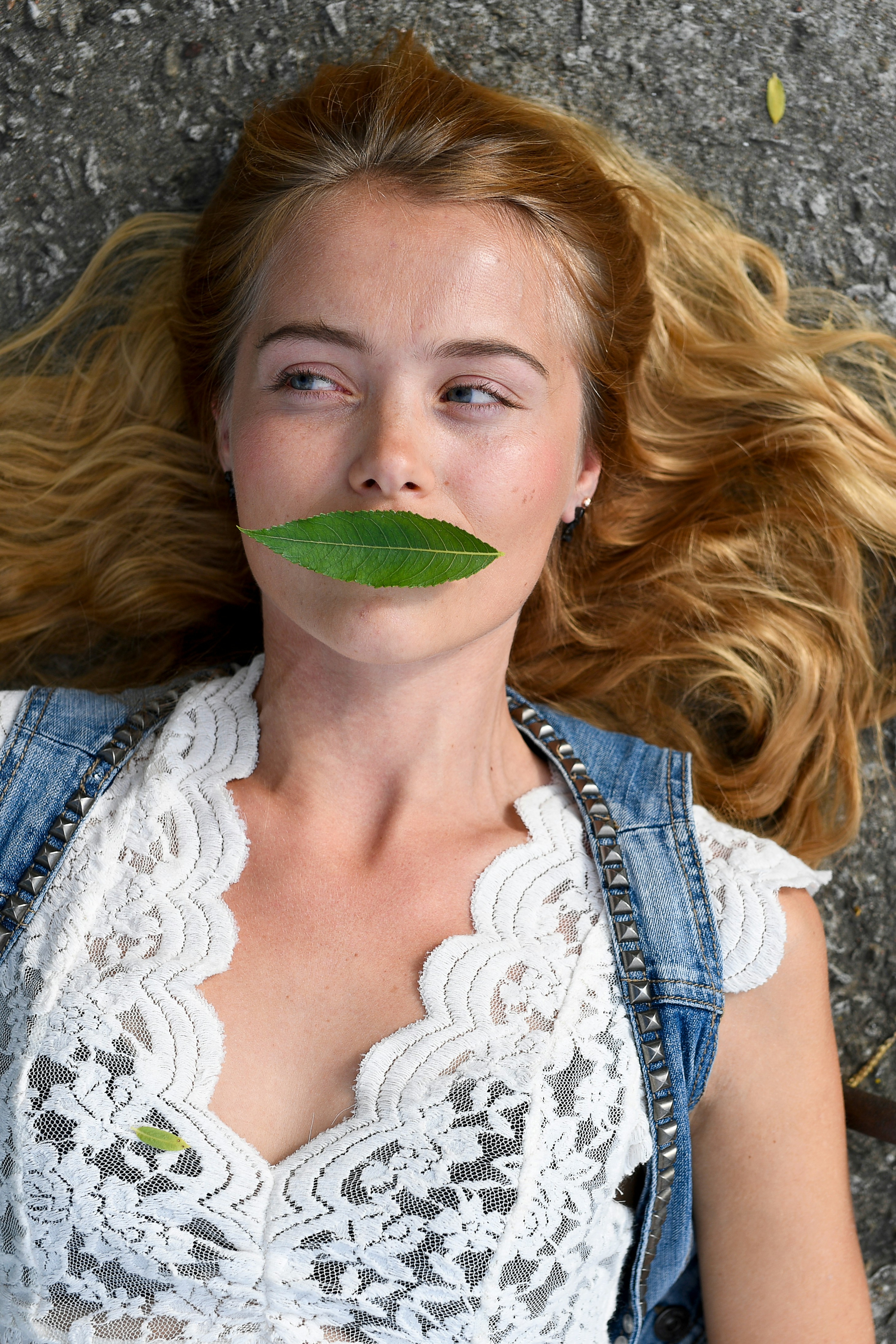 Une jeune femme avec une feuille verte couvrant la bouche