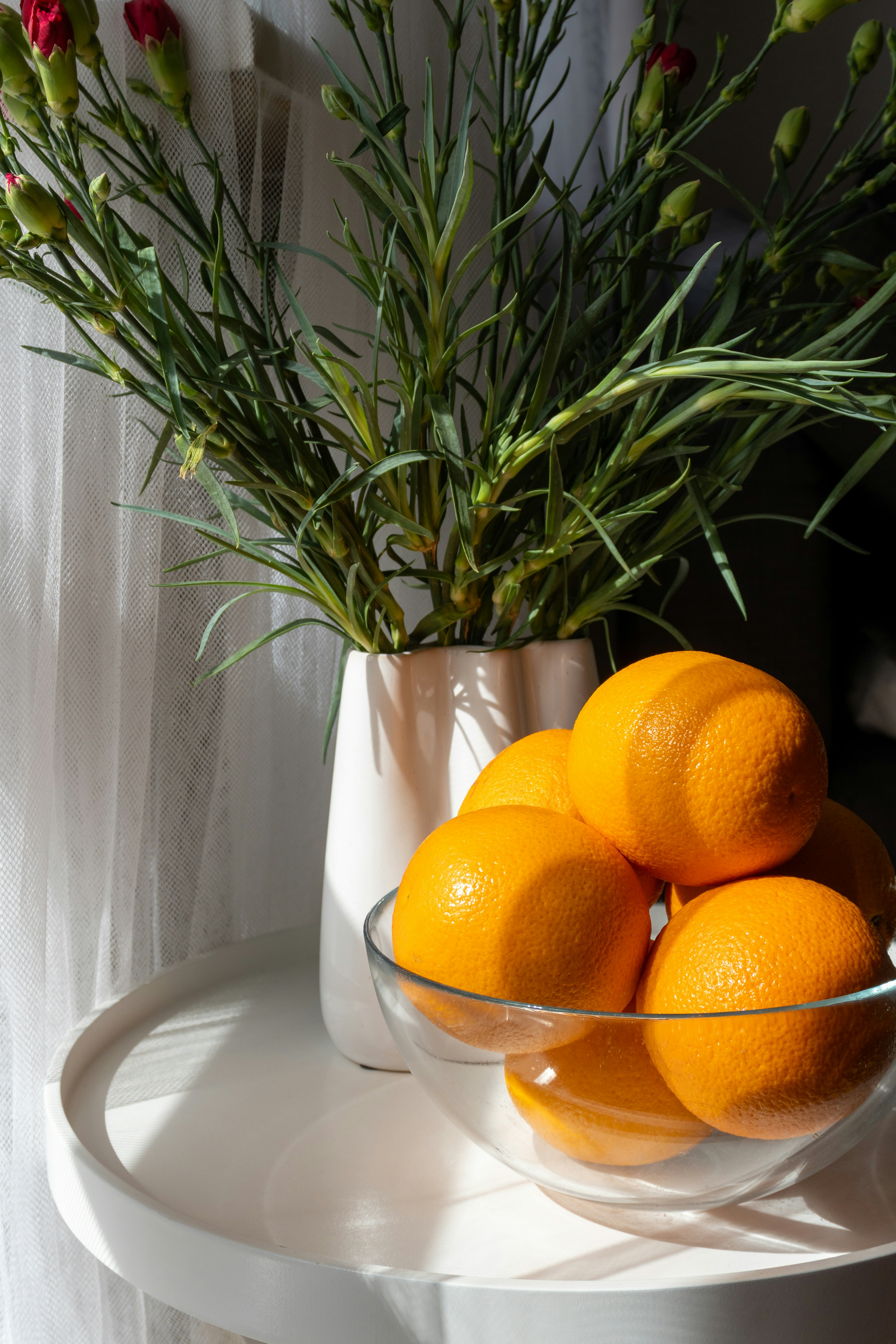 Flowers and oranges on a sunlit table