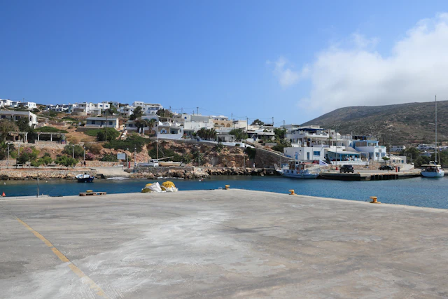 A Greek island harbor with white buildings and blue water
