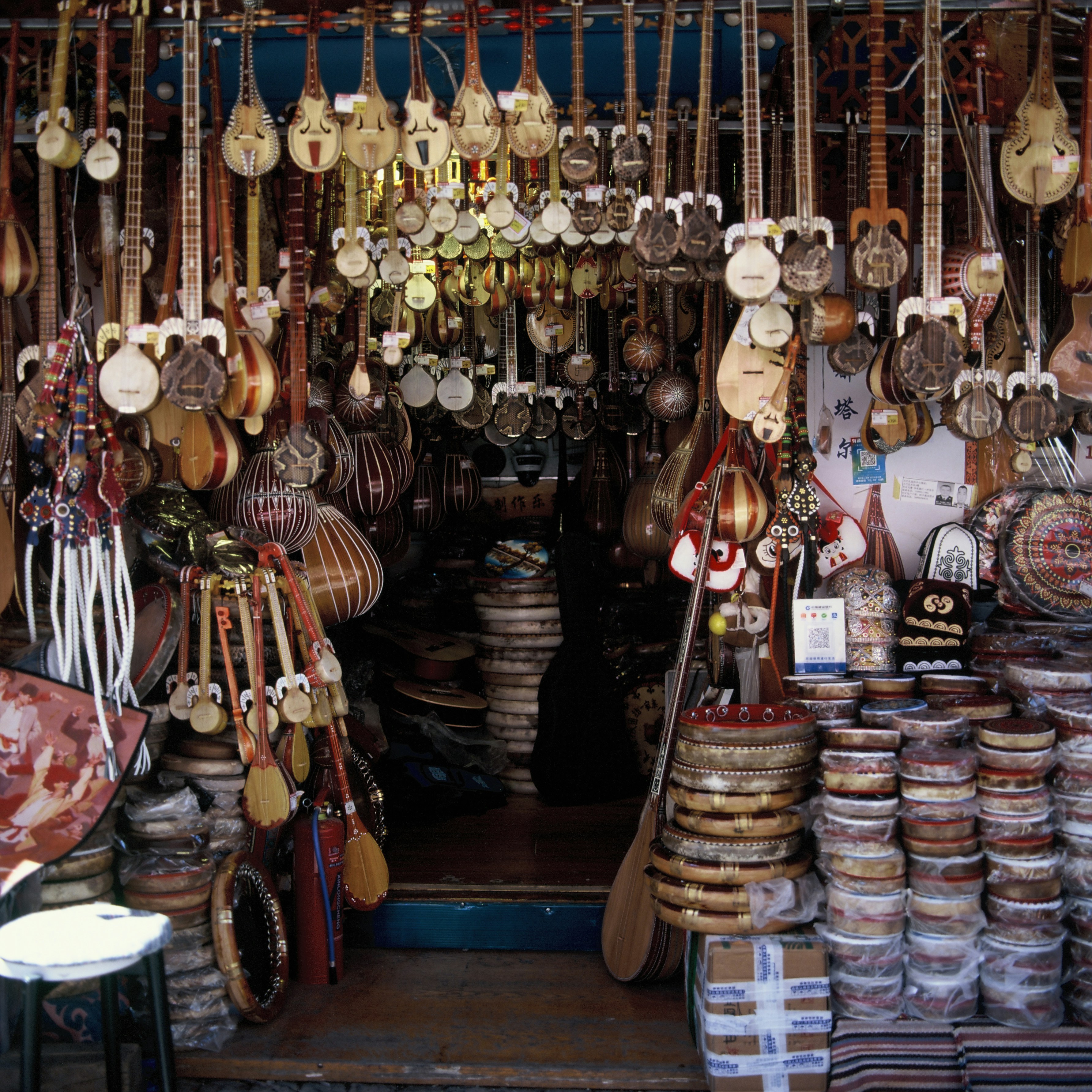 Numerous traditional string instruments and drums displayed in a shop.