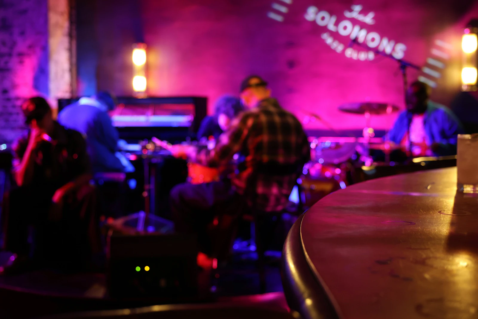 Musicians playing live in a dim, low-lit club