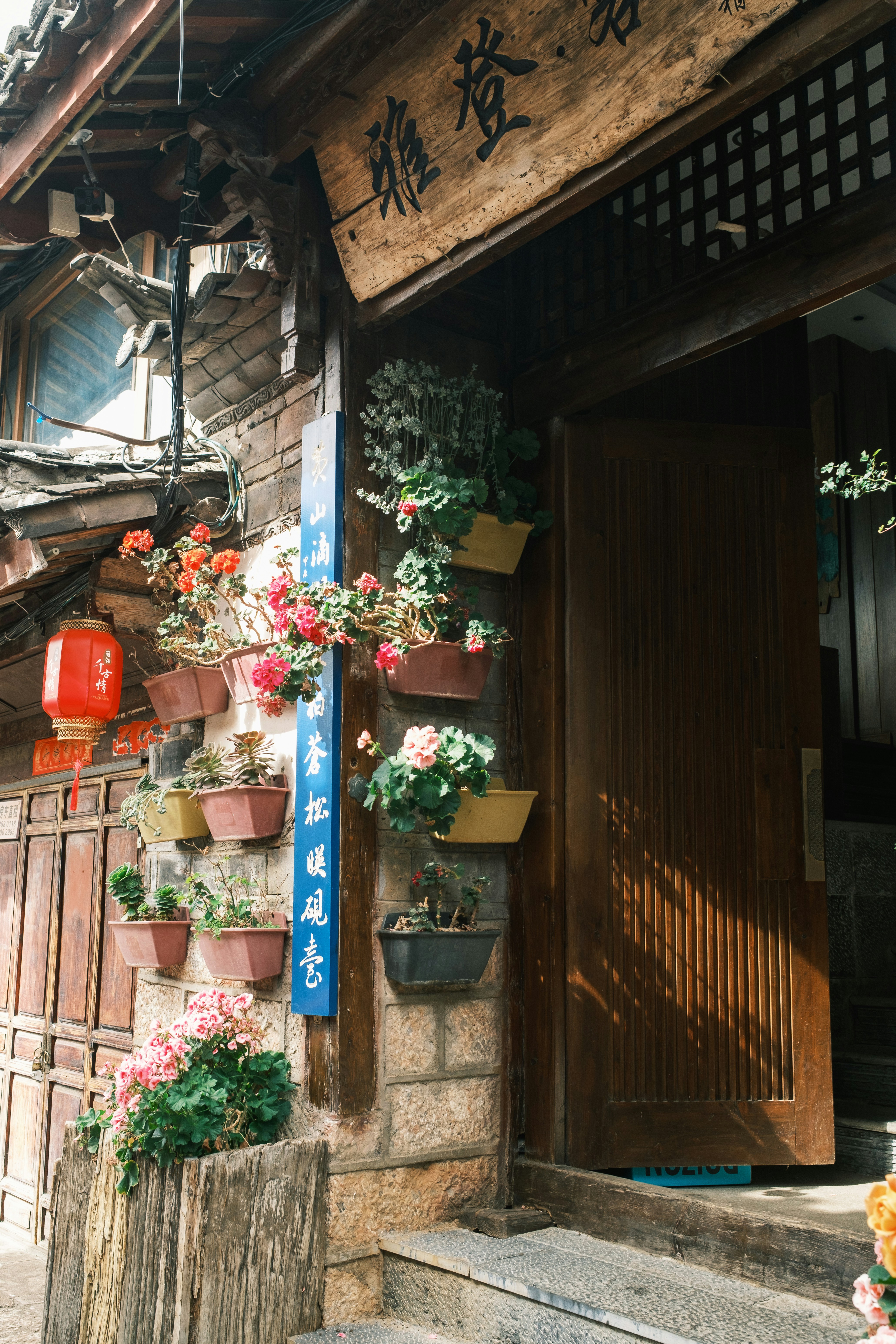 多くの色とりどりの鉢植えの花で飾られた伝統的な建物の入口。