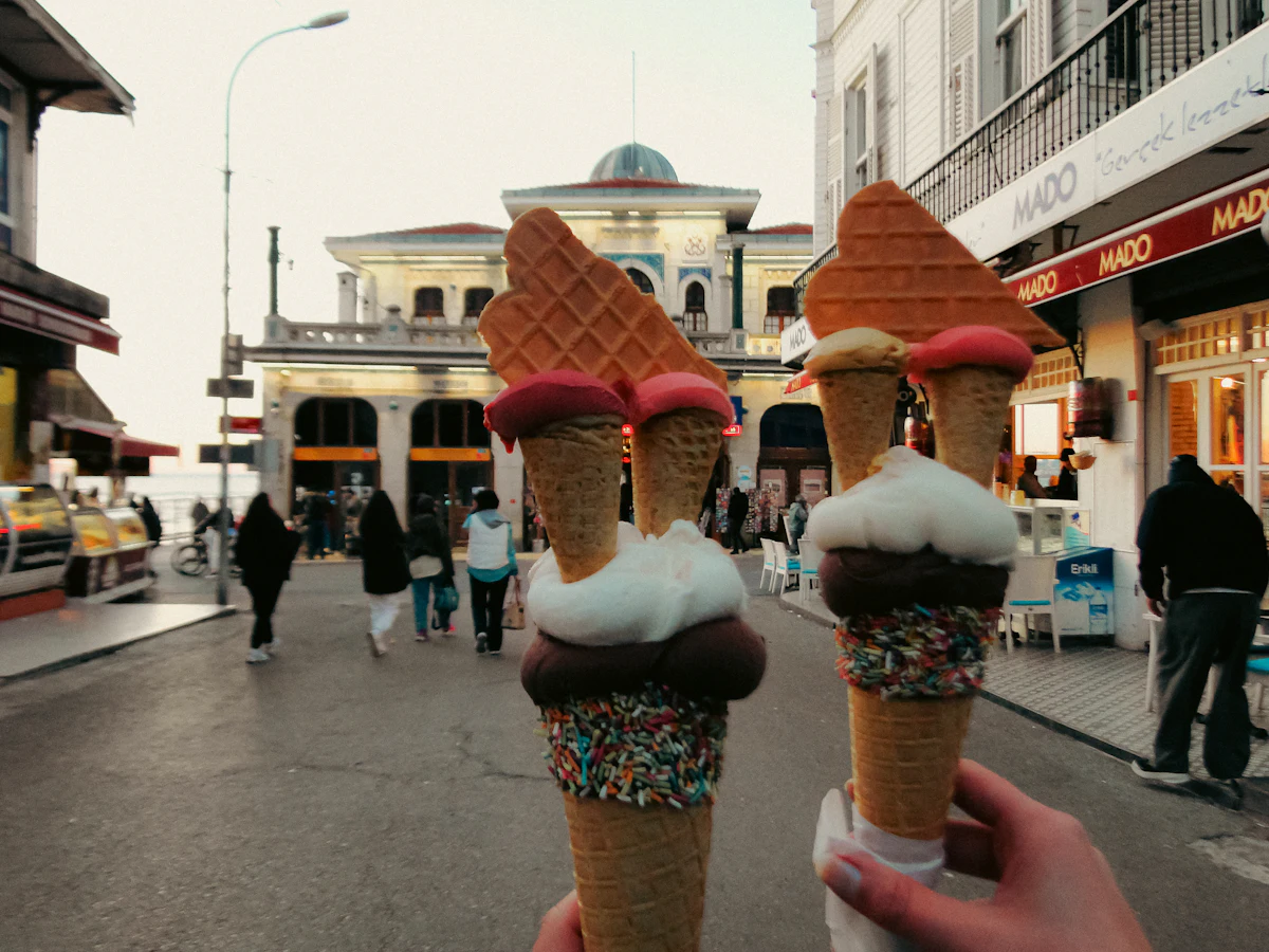Dua tangan memegang es krim cone di jalan kota