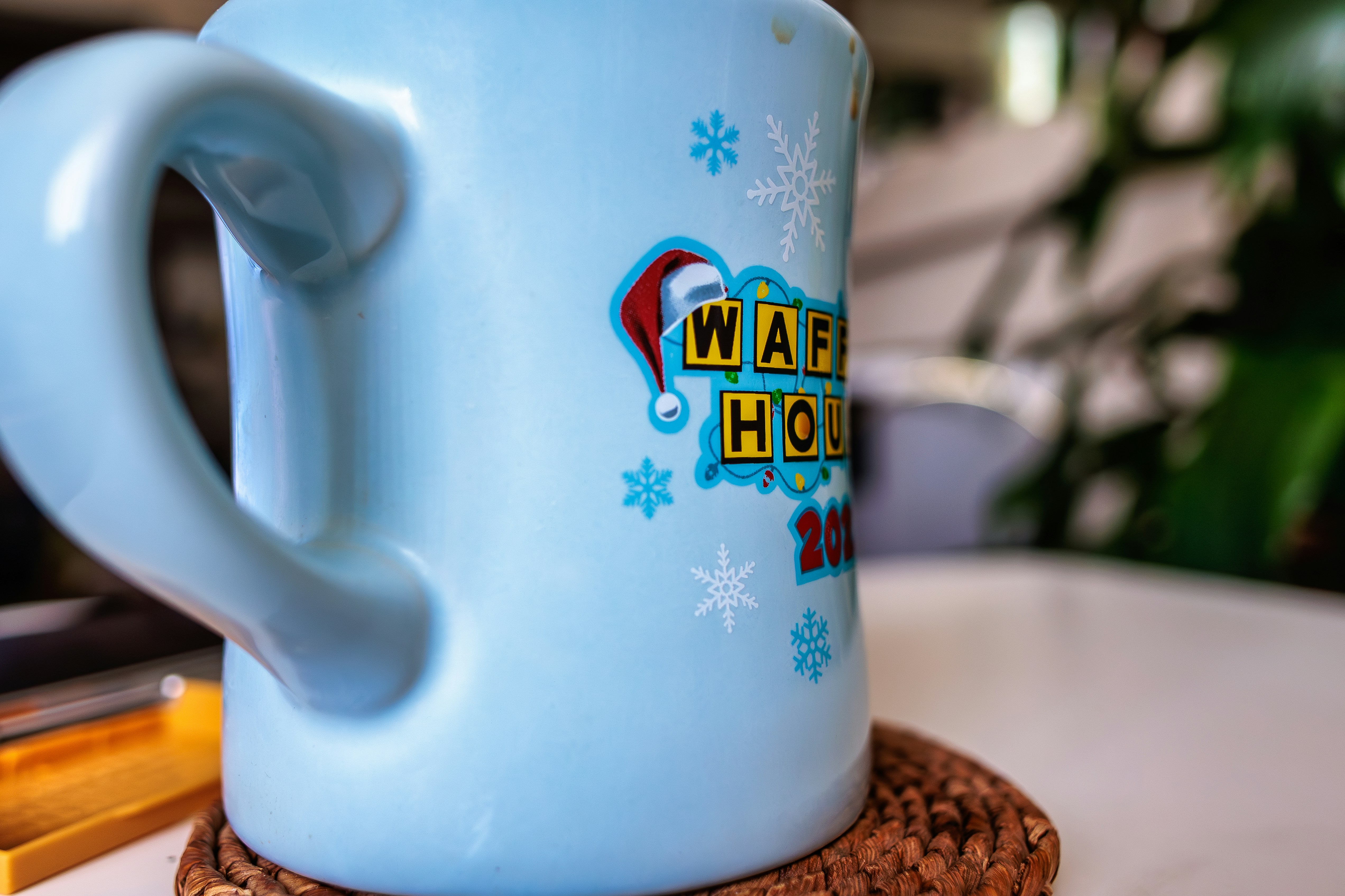 A light blue mug with a waffle house christmas logo.