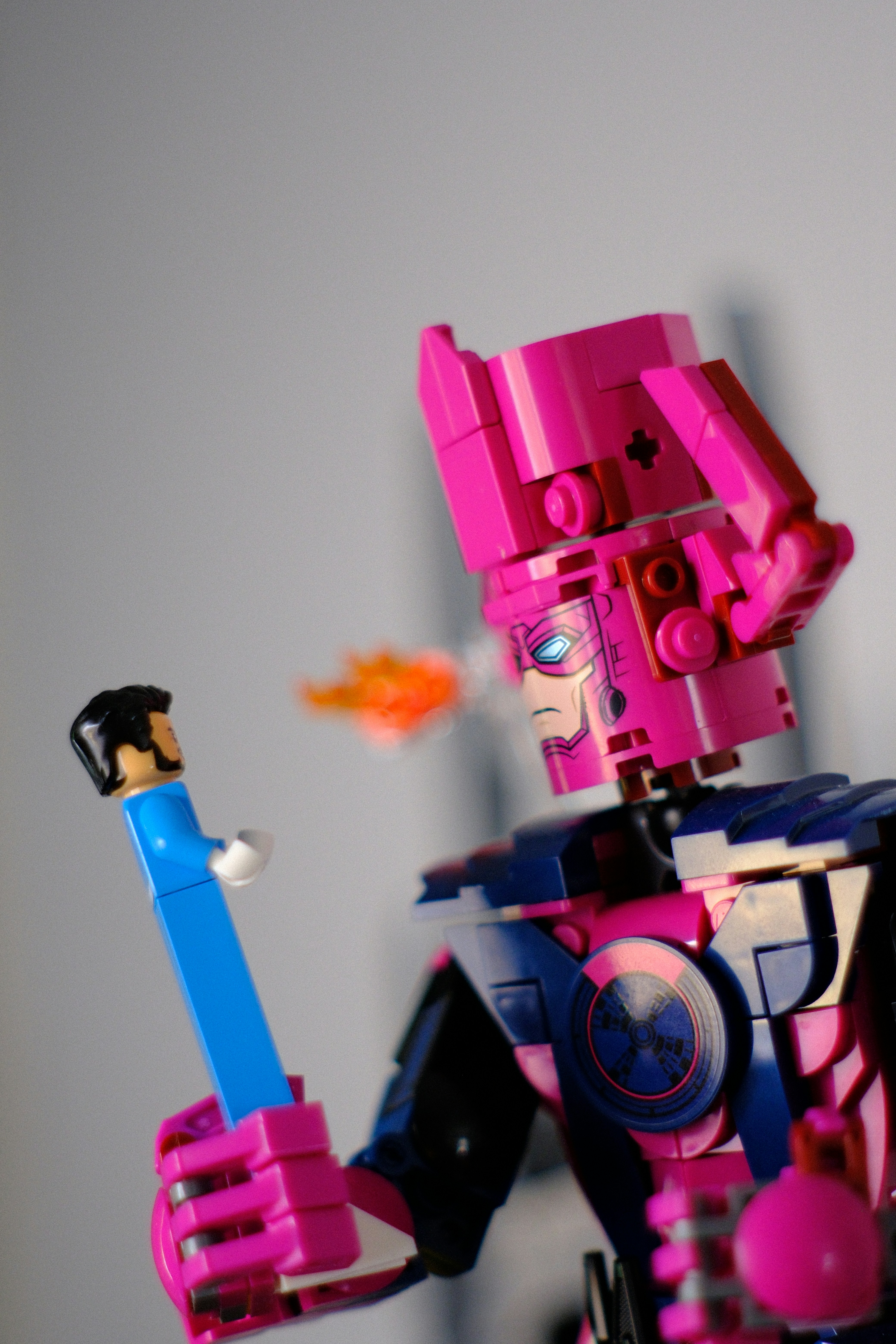 Figura de Lego Galactus escupiendo fuego a una minifigura más pequeña.