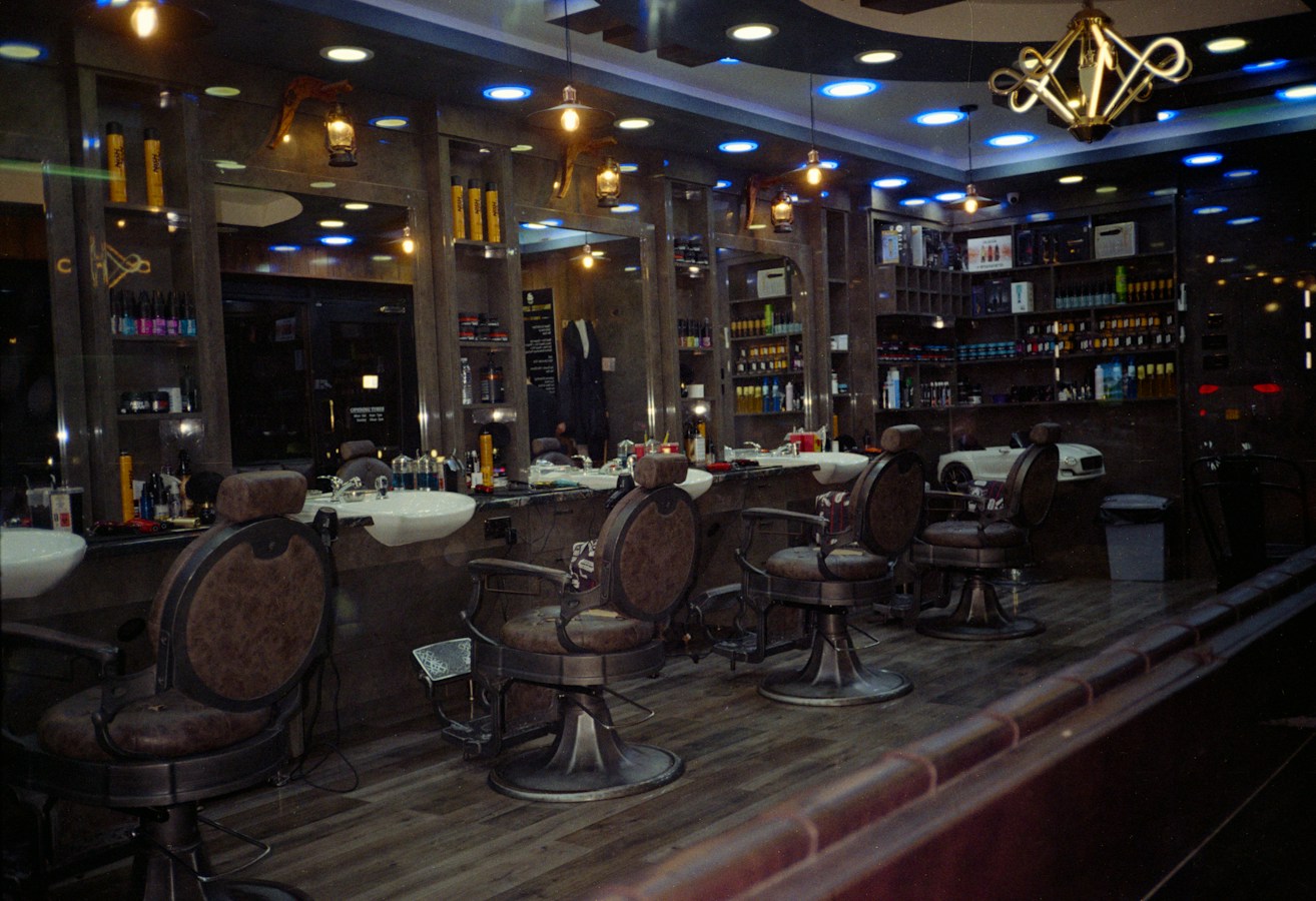 Interior de una barbería con varias estaciones de trabajo y espejos