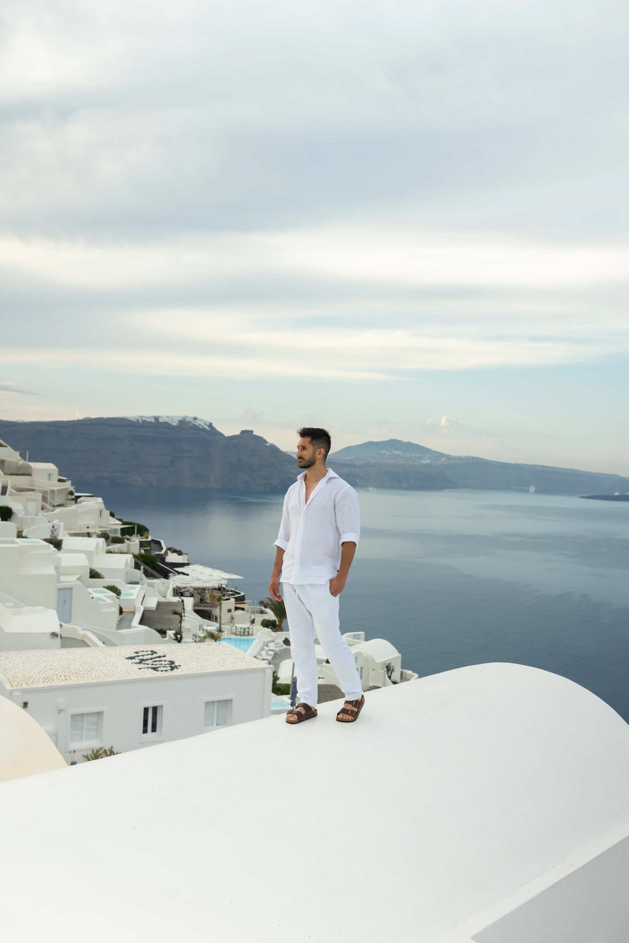 A man in white on a terrace above the sea