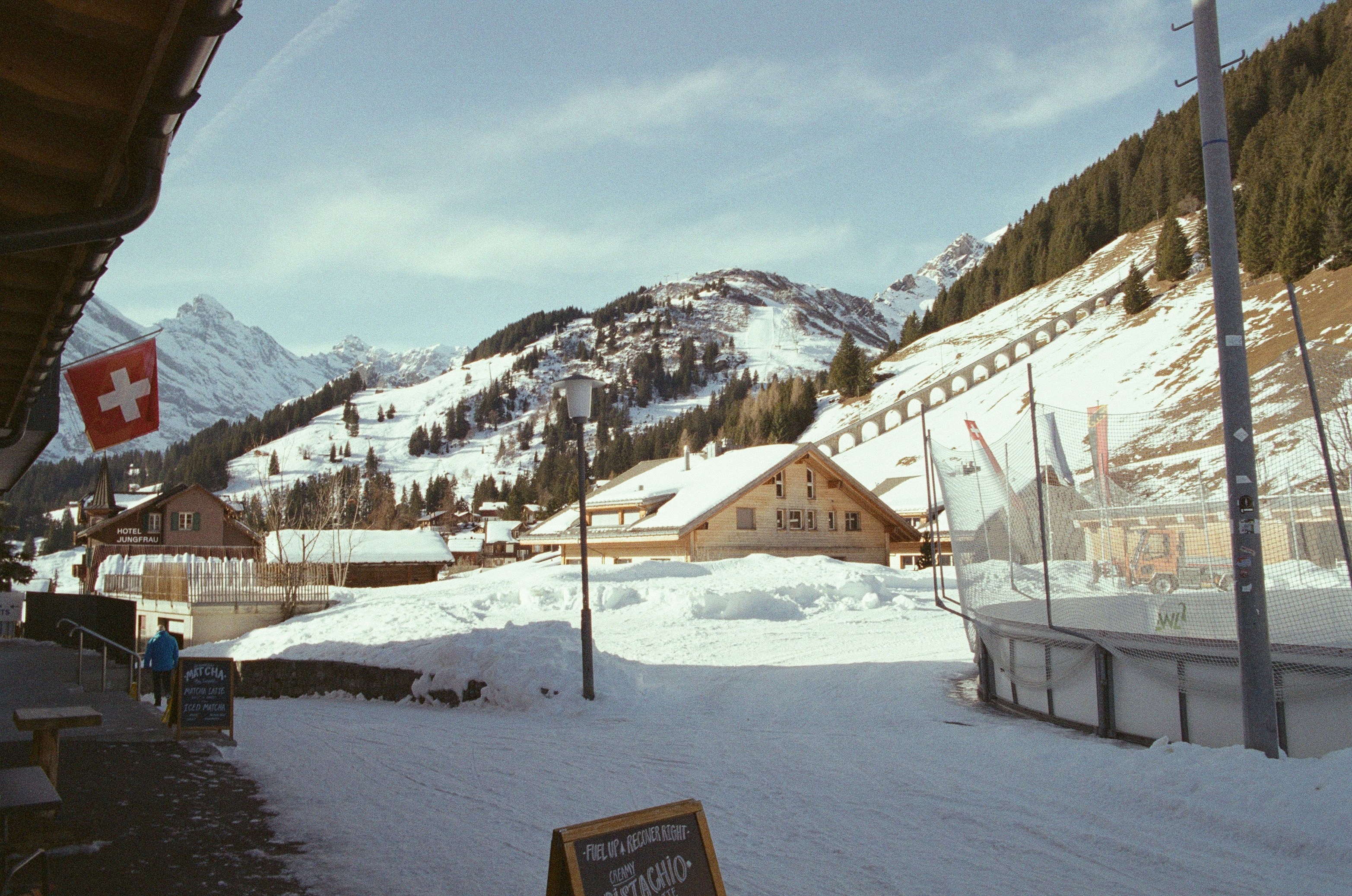 A snow-covered Swiss village with an outdoor ice rink, family-friendly in the mountains