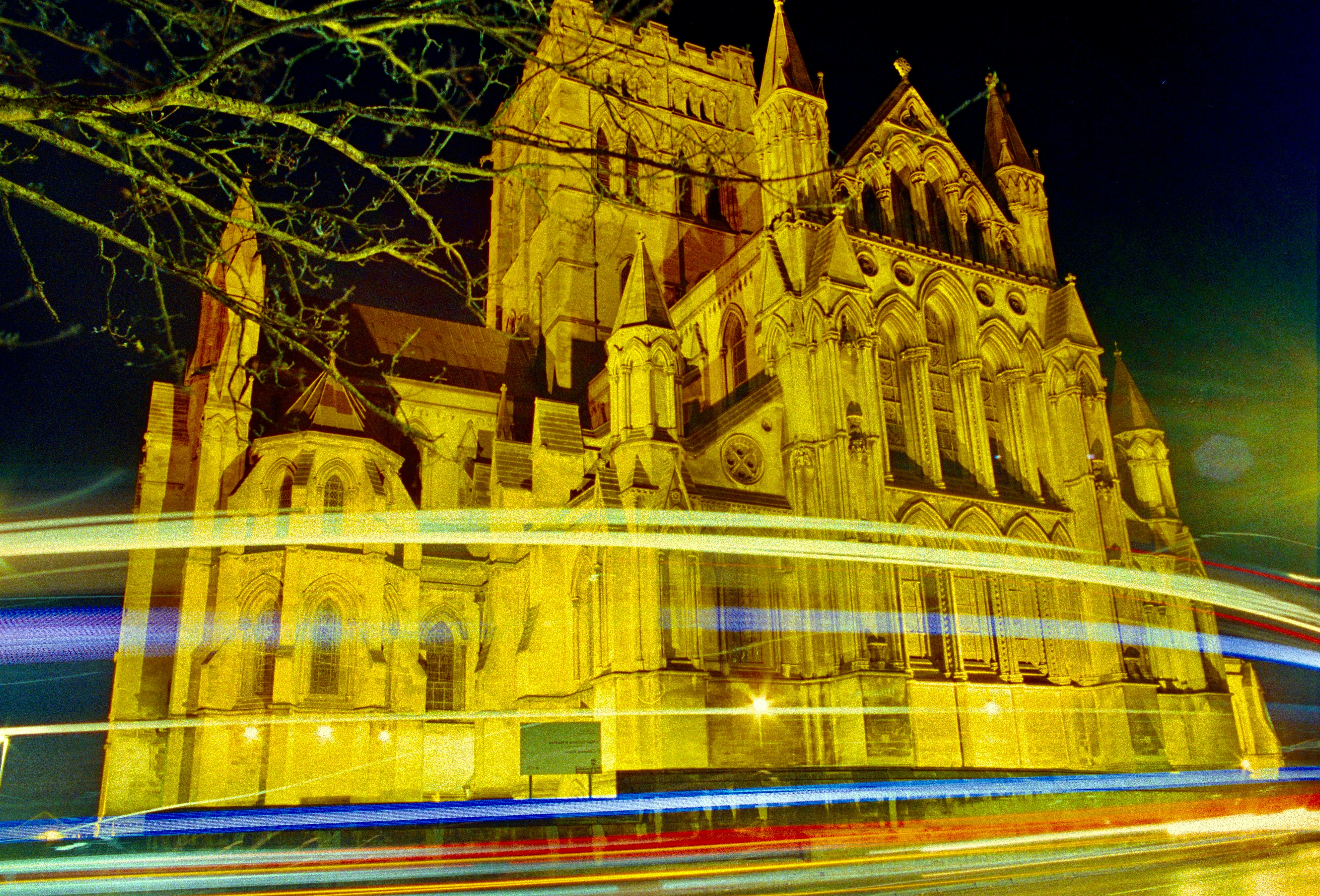 Historic cathedral illuminated at night with vibrant light trai…