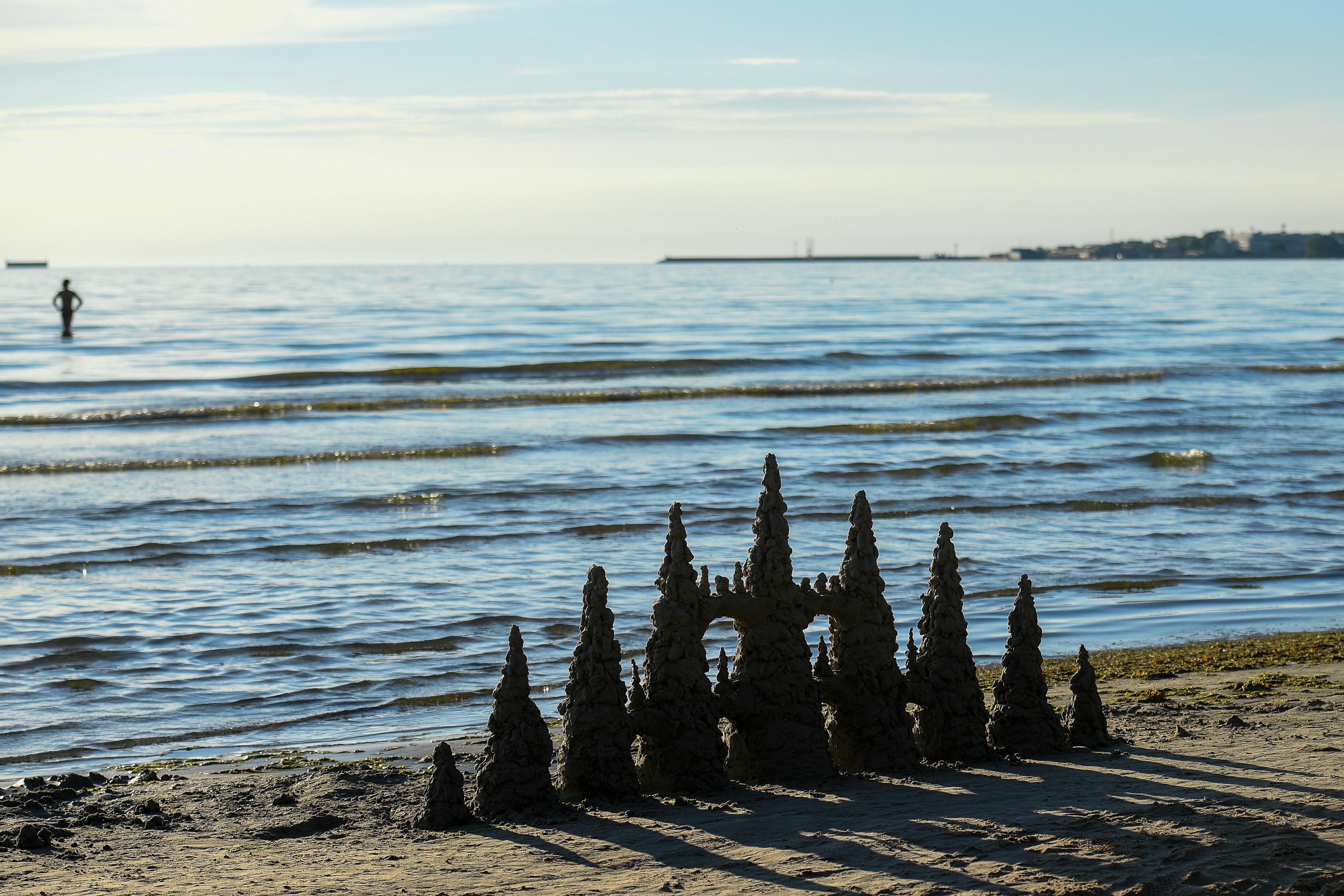 Castello di sabbia intricato su una spiaggia sabbiosa vicino al mare calmo.