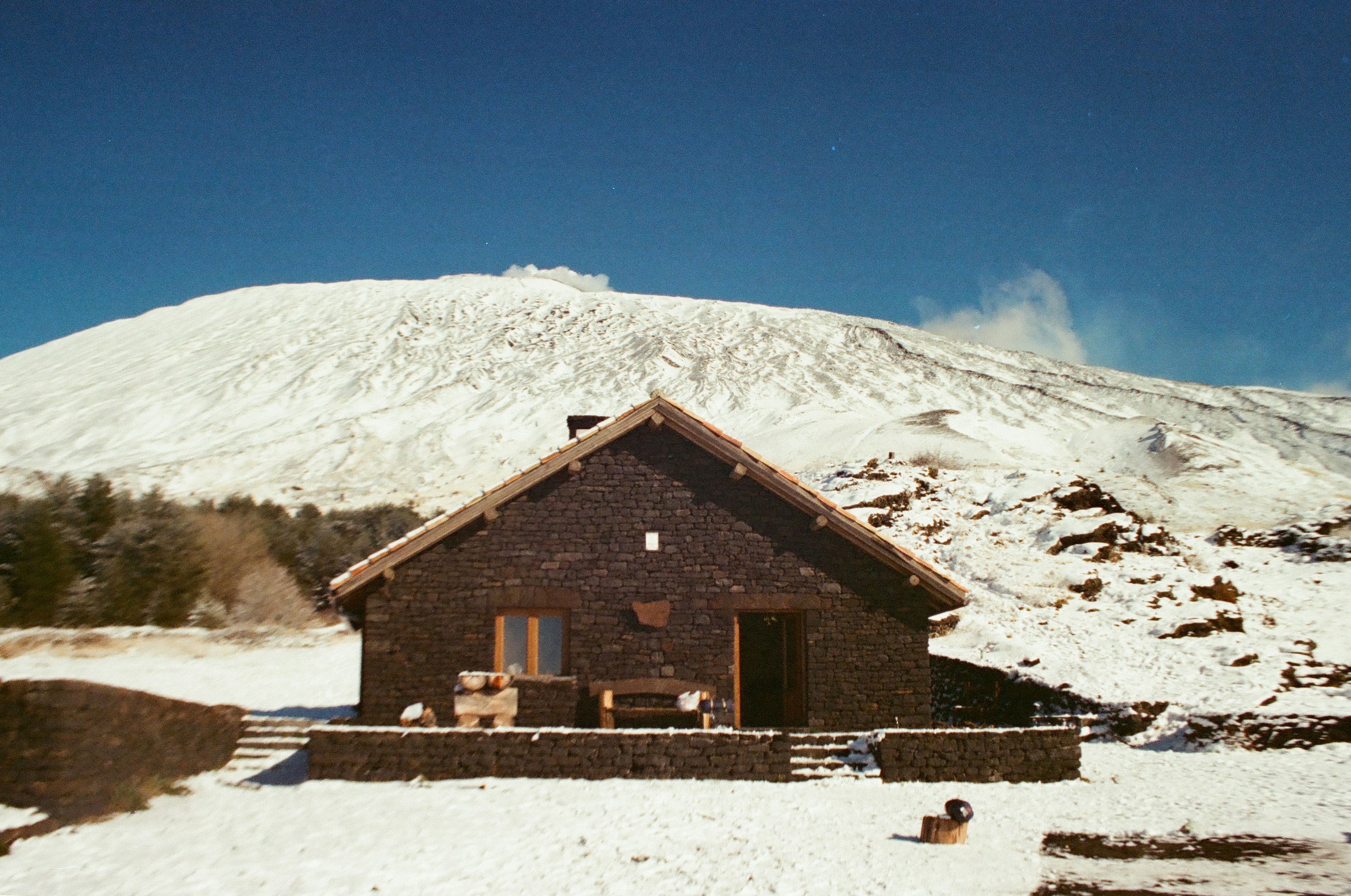 Snowy mountain landscape with a rustic wooden house