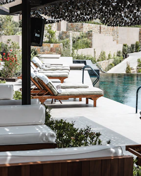 Luxury resort swimming pool with sun loungers and terraced landscaping