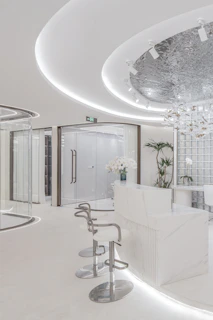 Modern white reception area with curved lines and glass partitions.