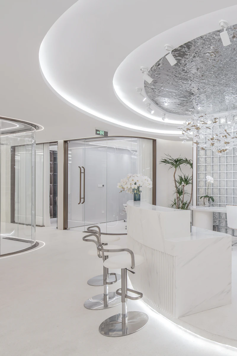 A bright, modern white reception area with curved lines and glass partitions
