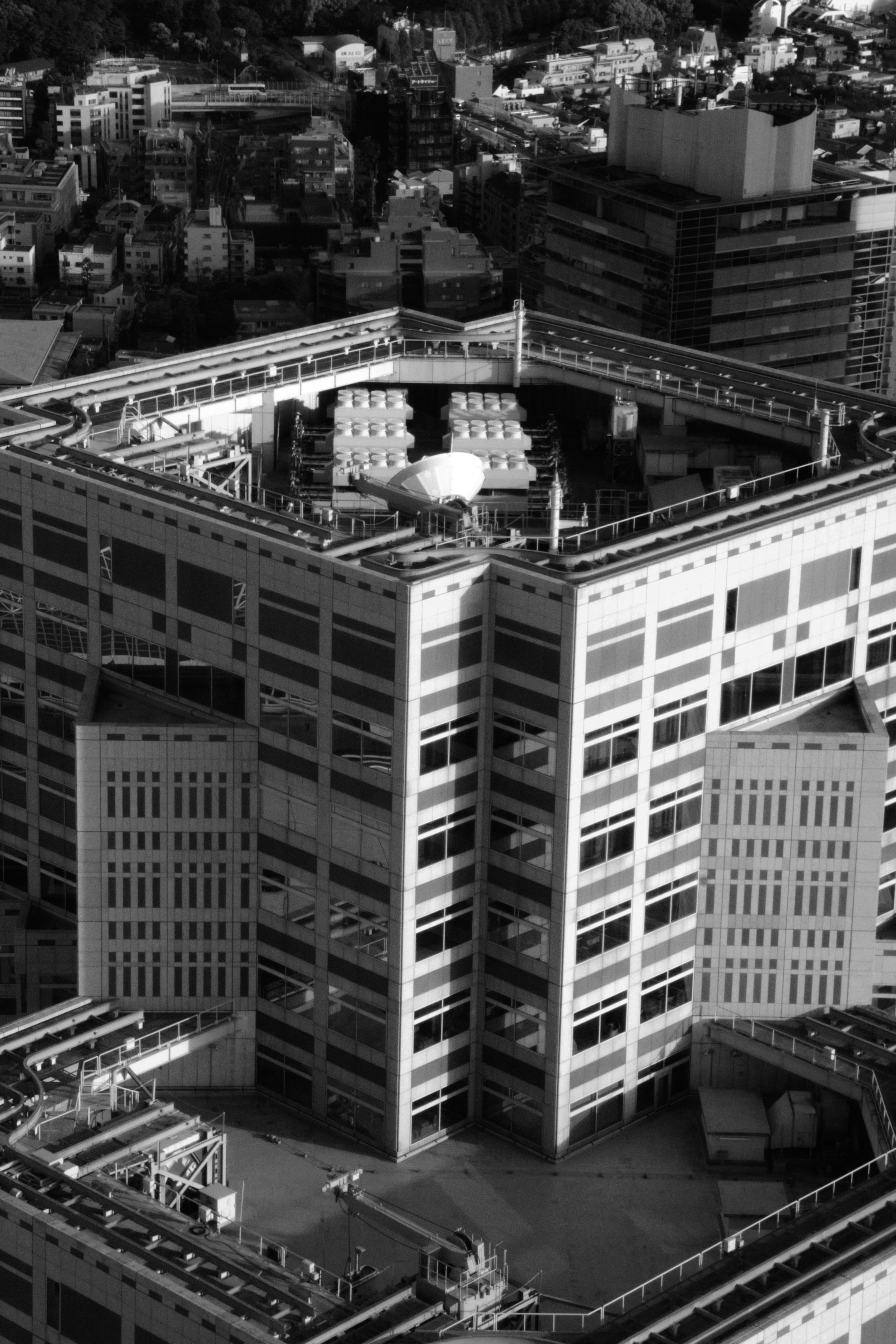 Hexagonal building with rooftop structures in a city
