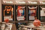 Basketballs displayed in front of framed sports jerseys.