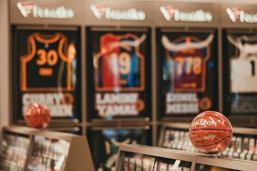 Basketballs displayed in front of framed sports jerseys.