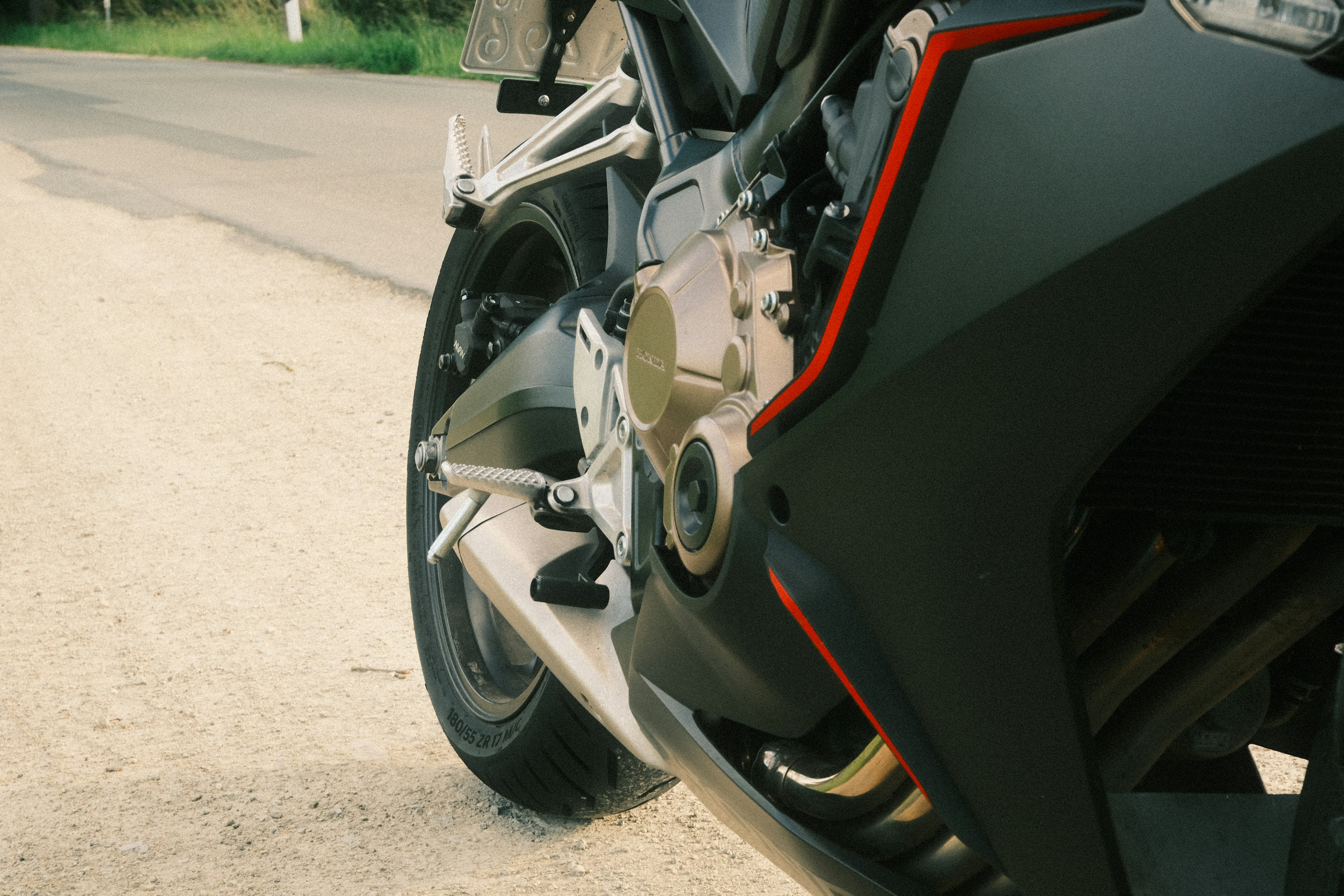 Sepeda motor hitam modern diparkir di jalan aspal.