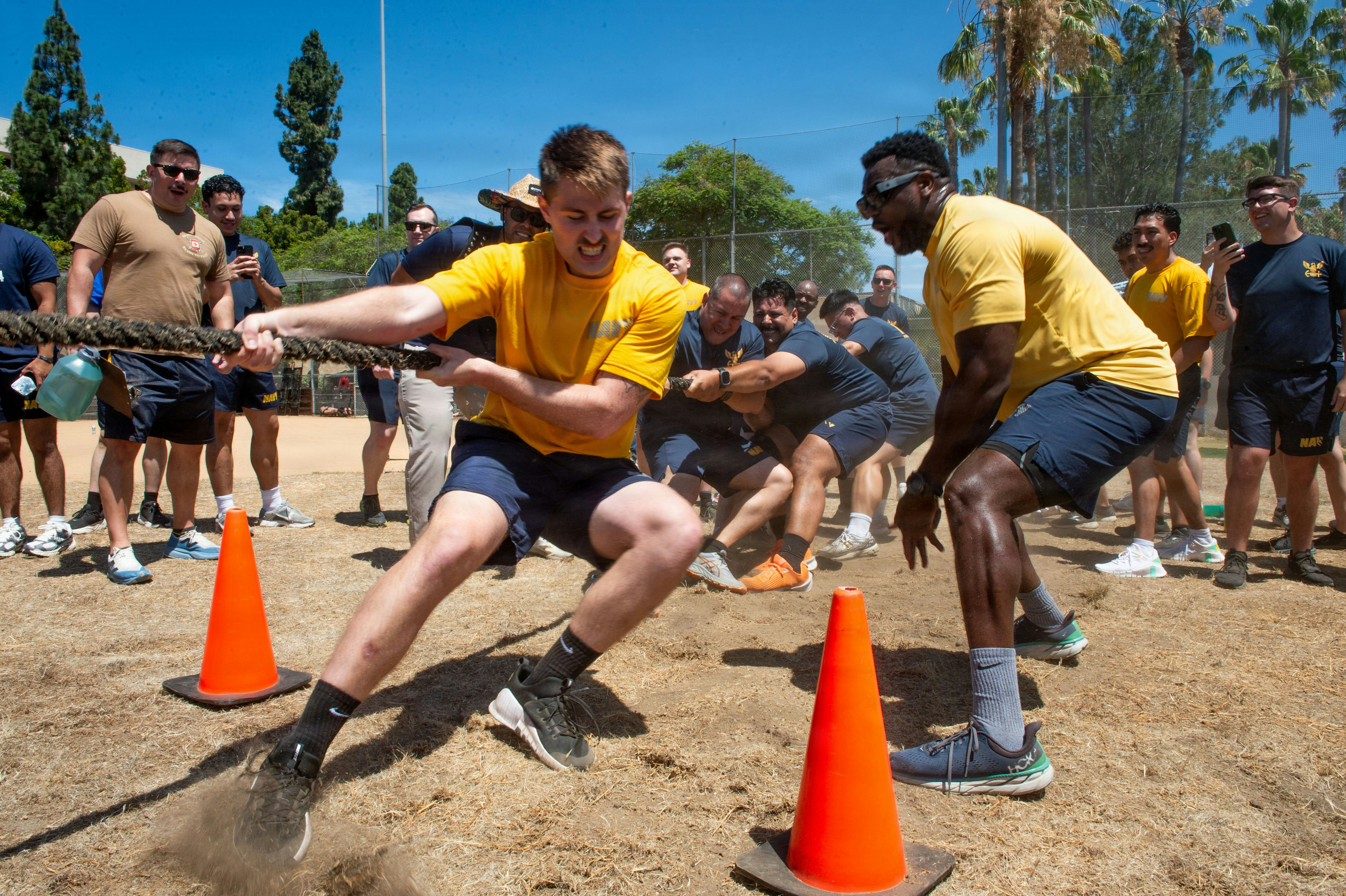 Sailors in uniform compete in an outdoor tug-of-war.