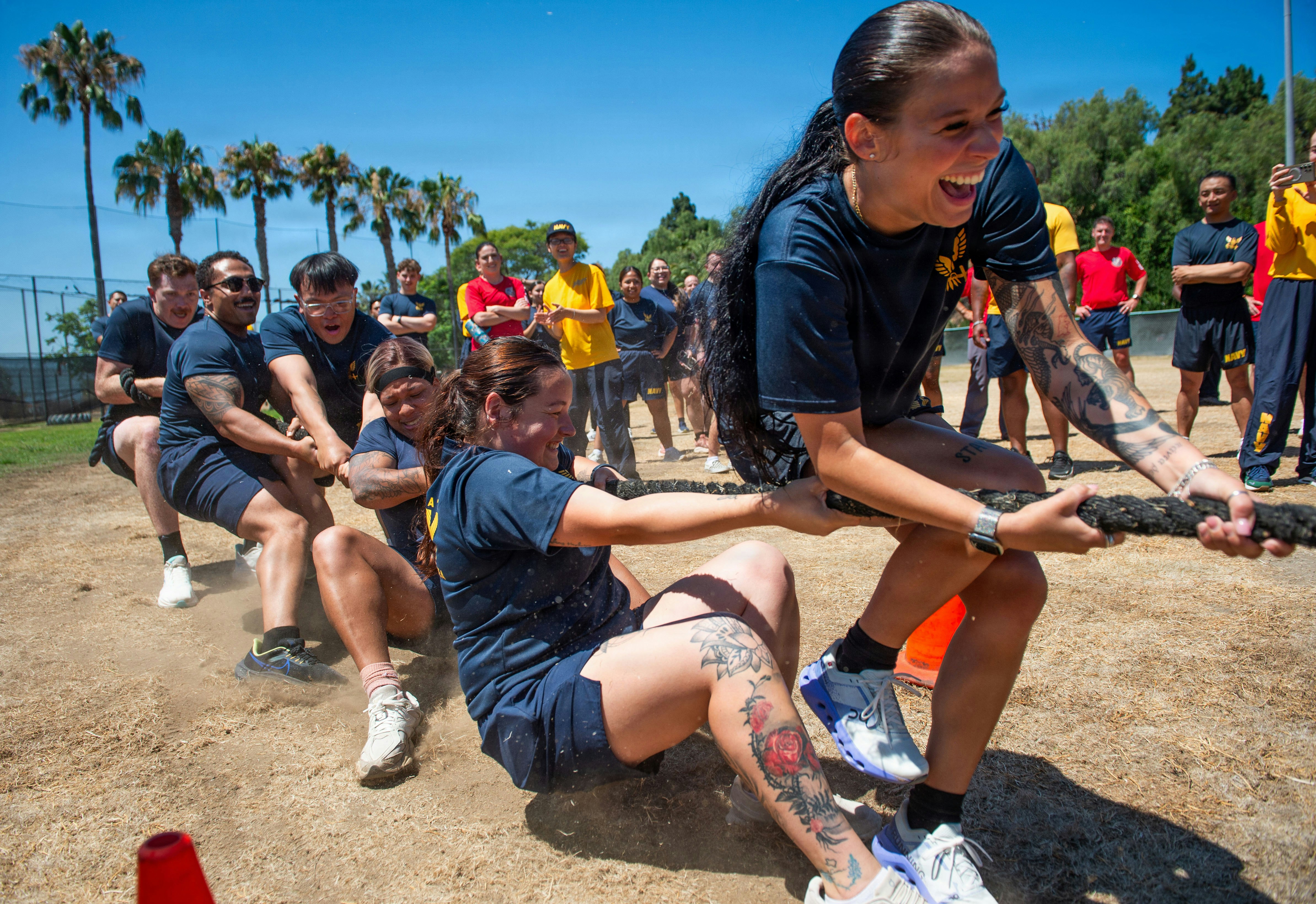 People vigorously compete in an outdoor tug-of-war game.