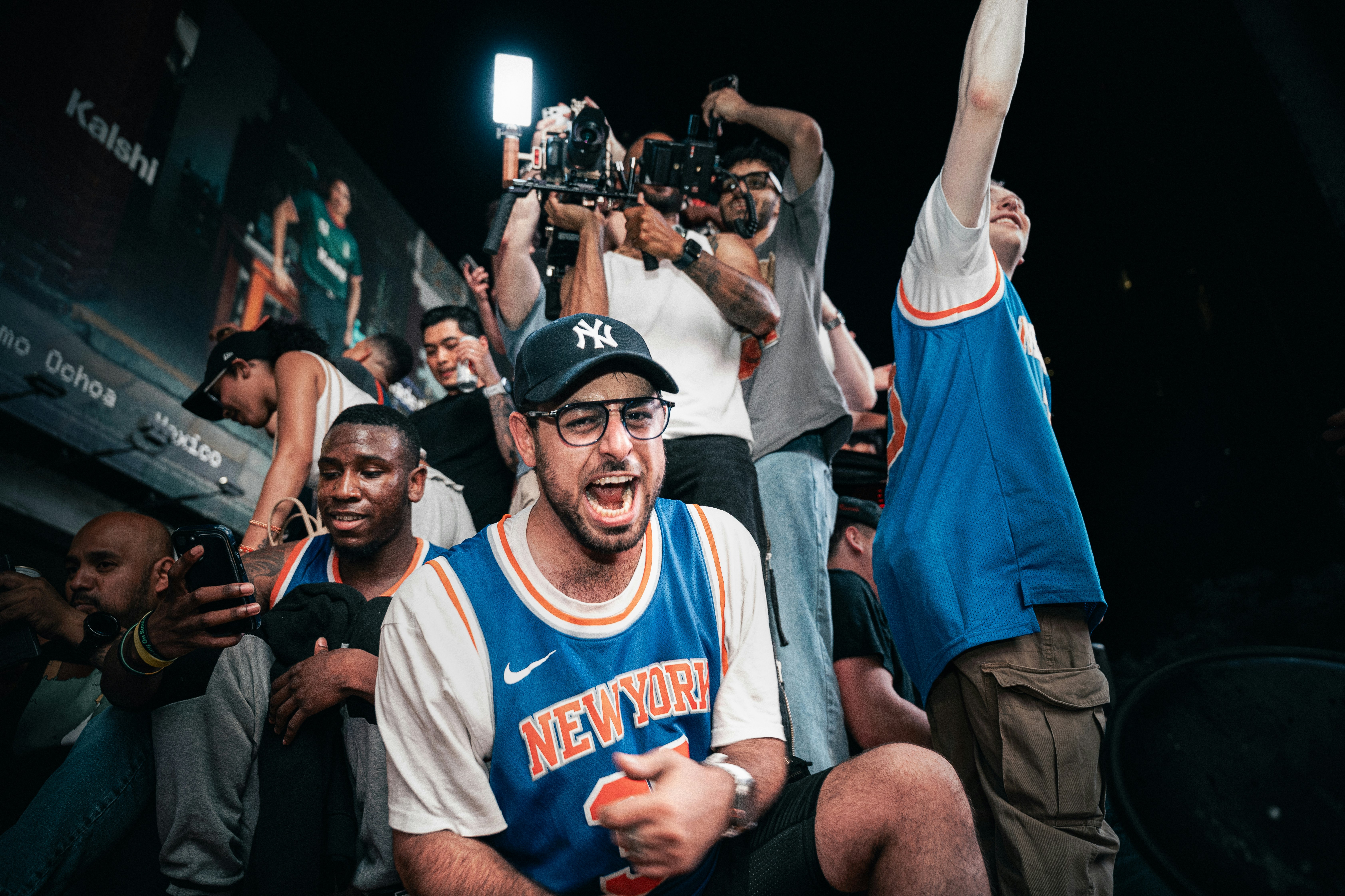 Man in new york jersey cheering excitedly in a crowd.