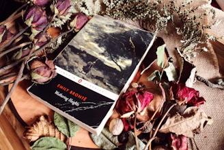 Classic novel wuthering heights surrounded by dried flowers and leaves.