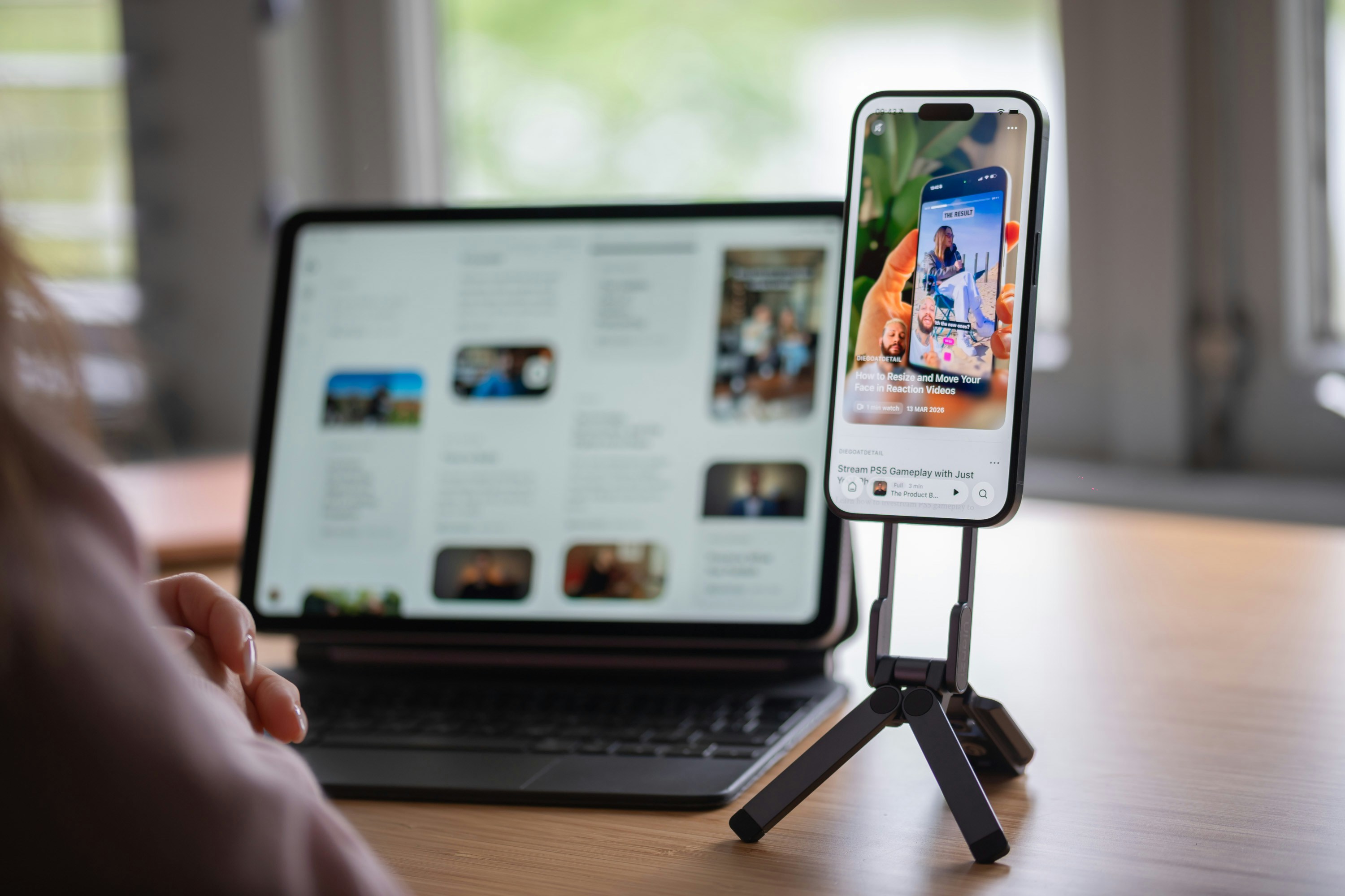 Smartphone on tripod shows social media next to a tablet.