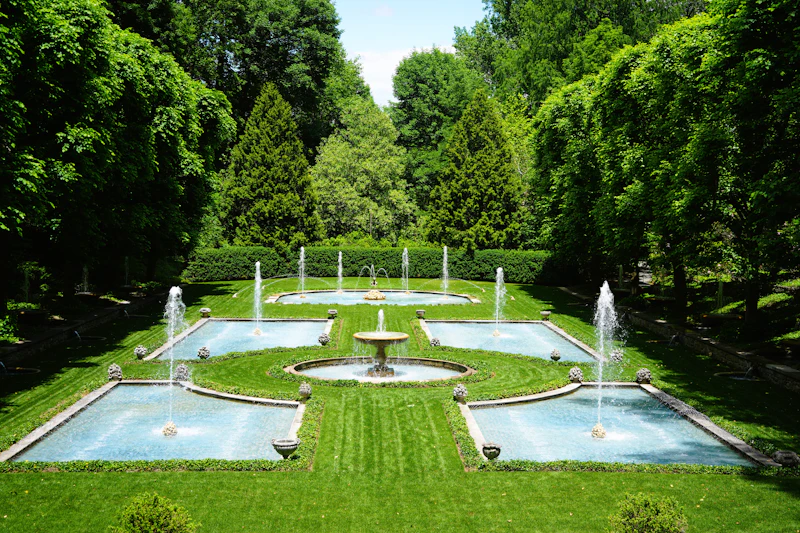 Formal garden with fountains, reflecting pools and tall evergreen hedges