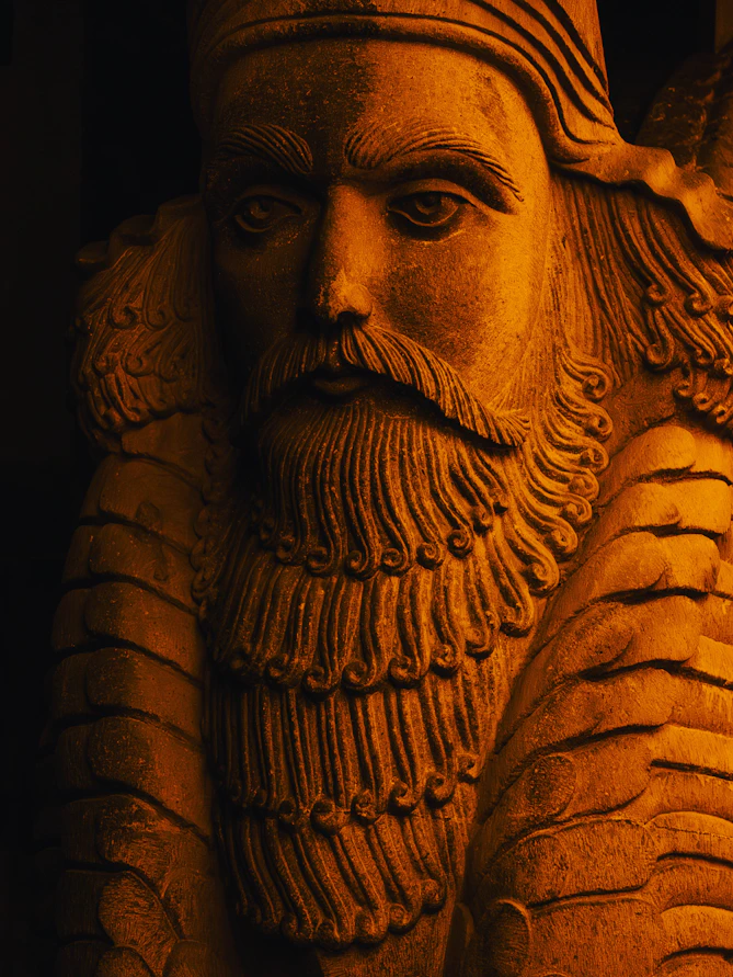 Detailed stone carving of a bearded man with a headdress.