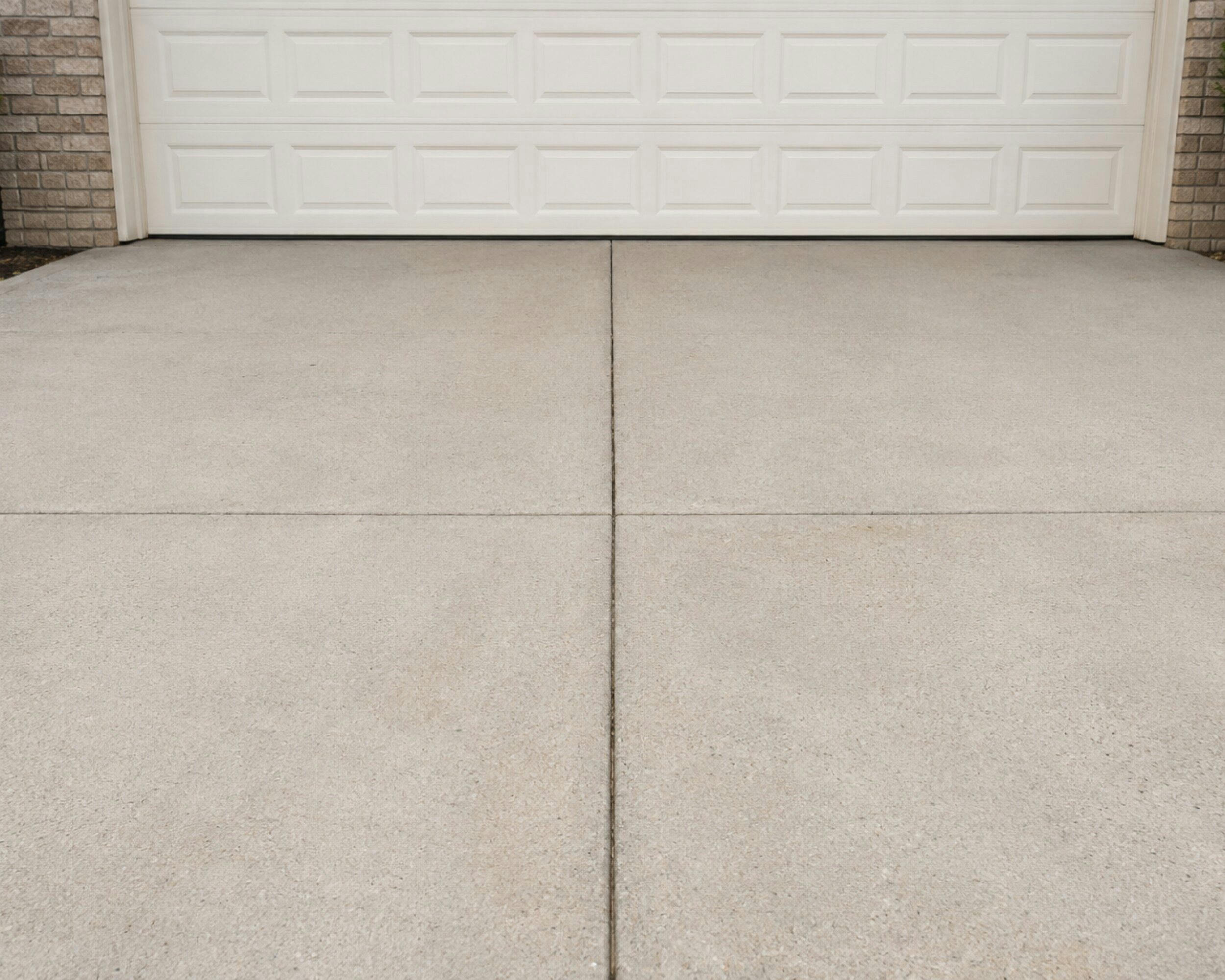 Freshly pressure-washed driveway and walkway leading to a home