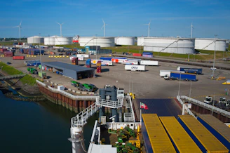 Industrial port with a ferry, trucks, and storage tanks