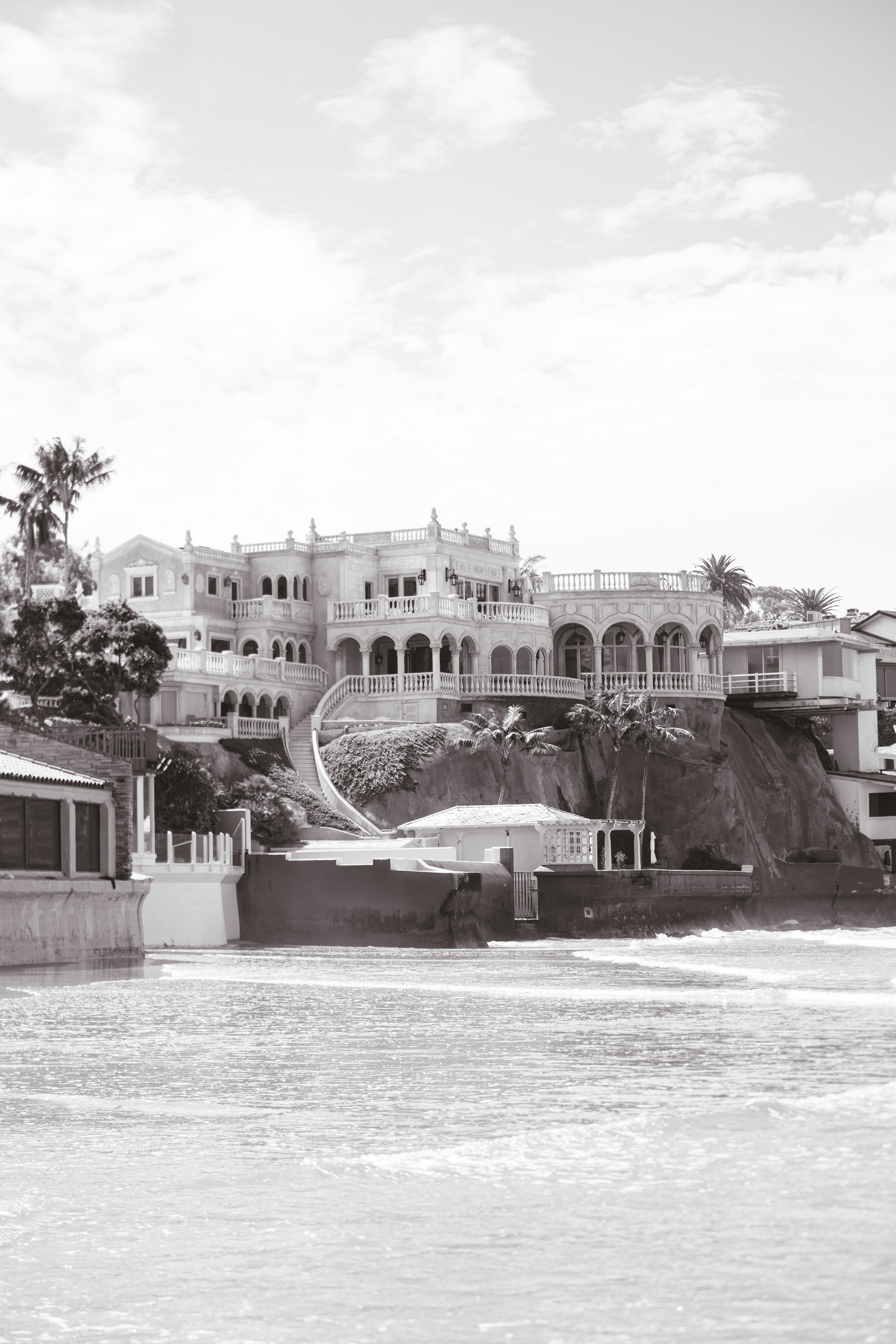 Grand mansion on a coastal cliff in monochrome.