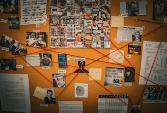 Investigation board with red string connecting photos and documents.